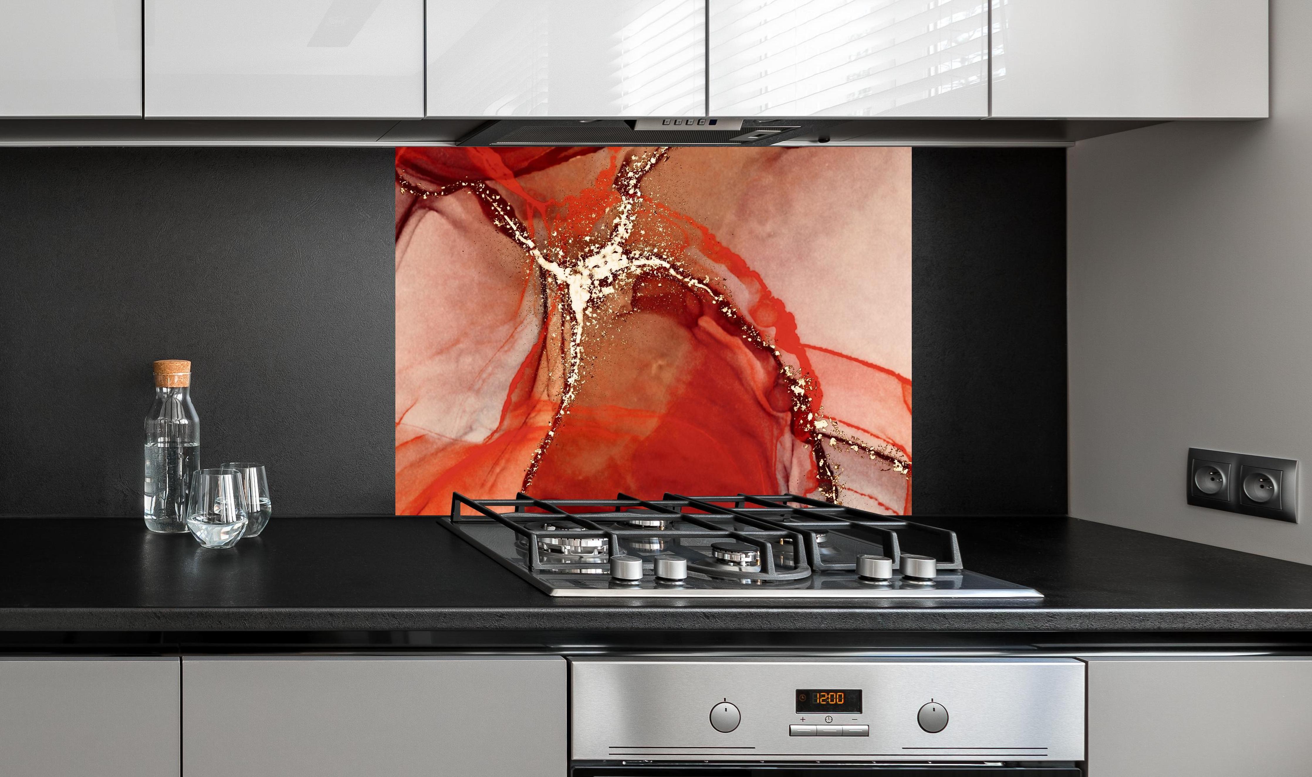 Spritzschutz - Rötliche Tinte mit Goldelementen an edler Anthrazit-Wand hinter silbernem Gasherd