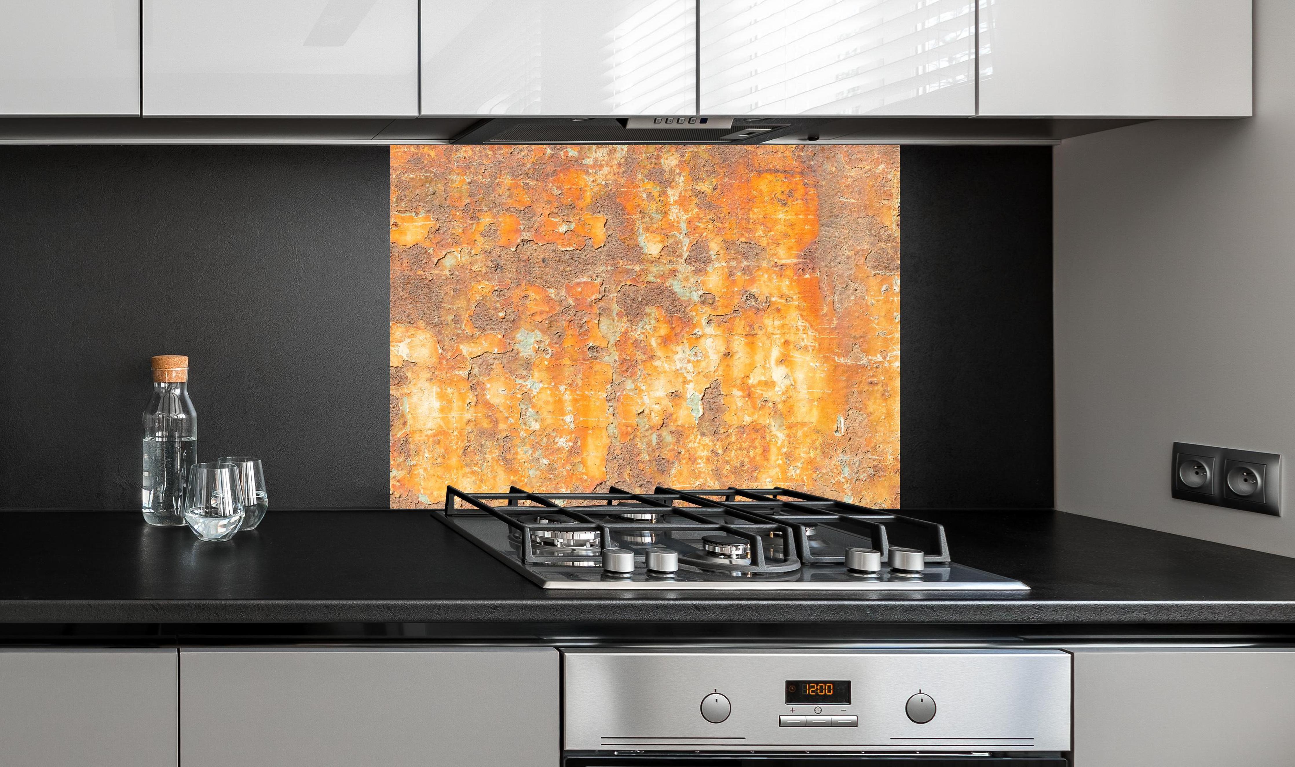 Spritzschutz - Rostige Betonwand an edler Anthrazit-Wand hinter silbernem Gasherd