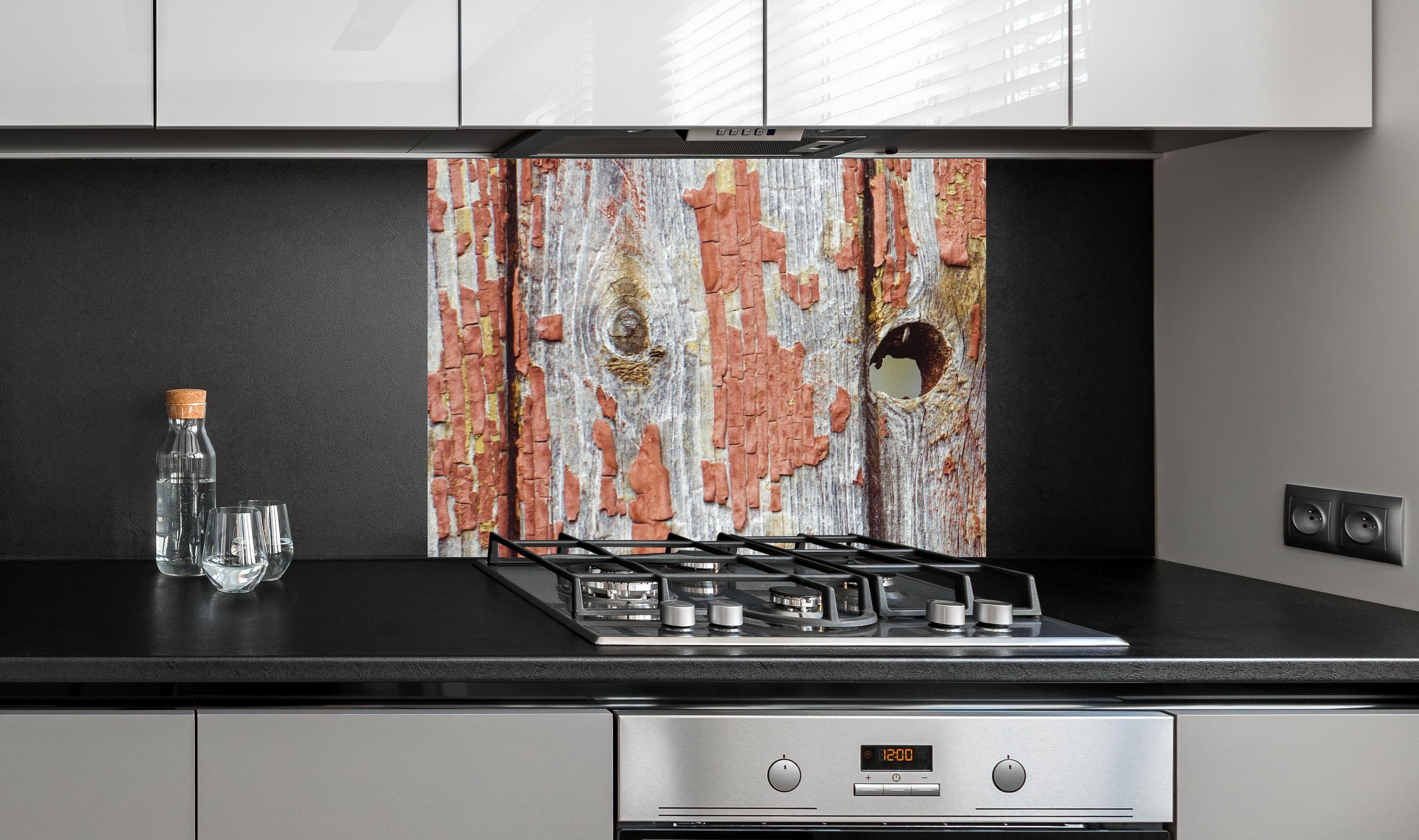 Spritzschutz - Rustikale Holzbretter mit Loch an edler Anthrazit-Wand hinter silbernem Gasherd