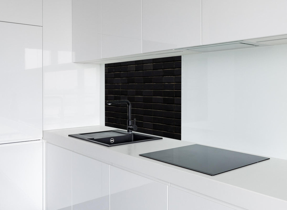 Spritzschutz - Schwarze Backsteinmauer mit goldener Akzent hinter modernem schwarz-matten Spülbecken in weißer Hochglanz-Küche