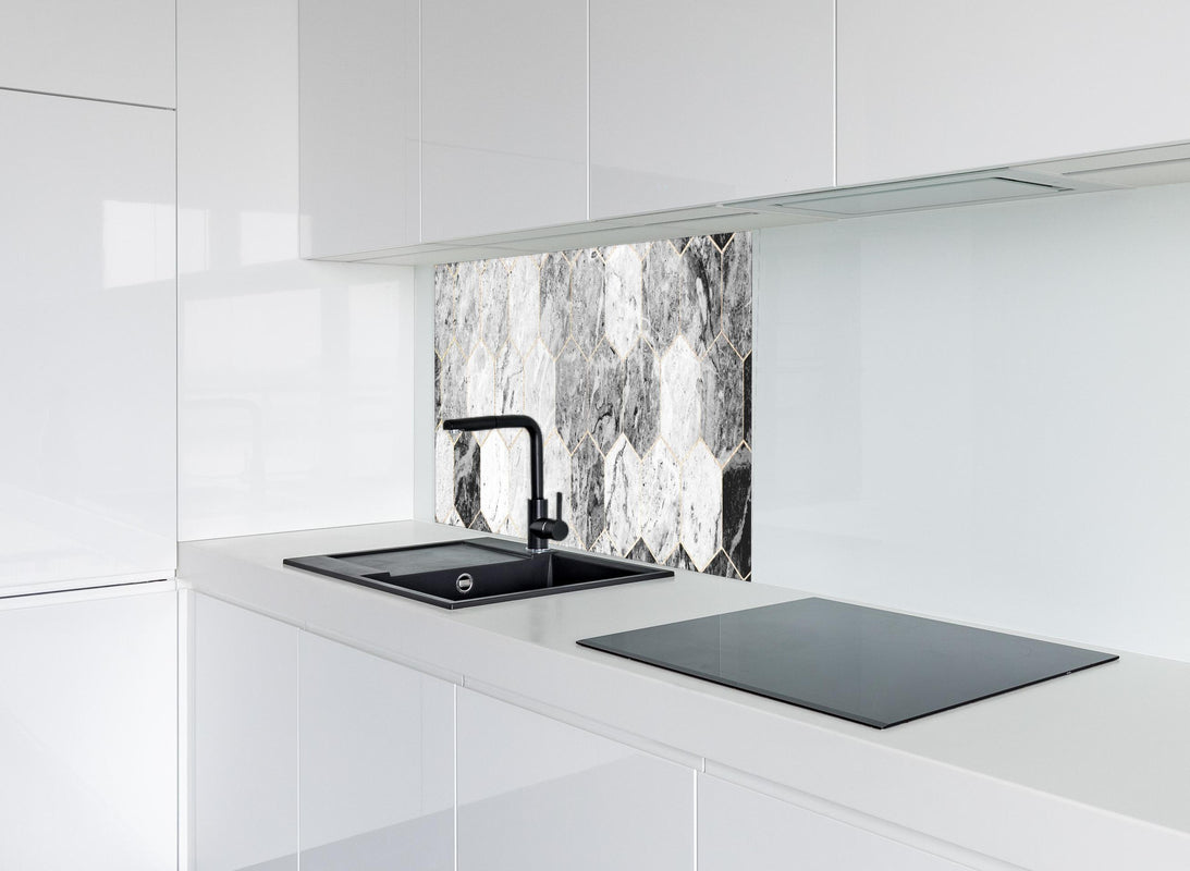 Spritzschutz - Sechseckiger gräulicher Marmor mit Goldumrandung hinter modernem schwarz-matten Spülbecken in weißer Hochglanz-Küche