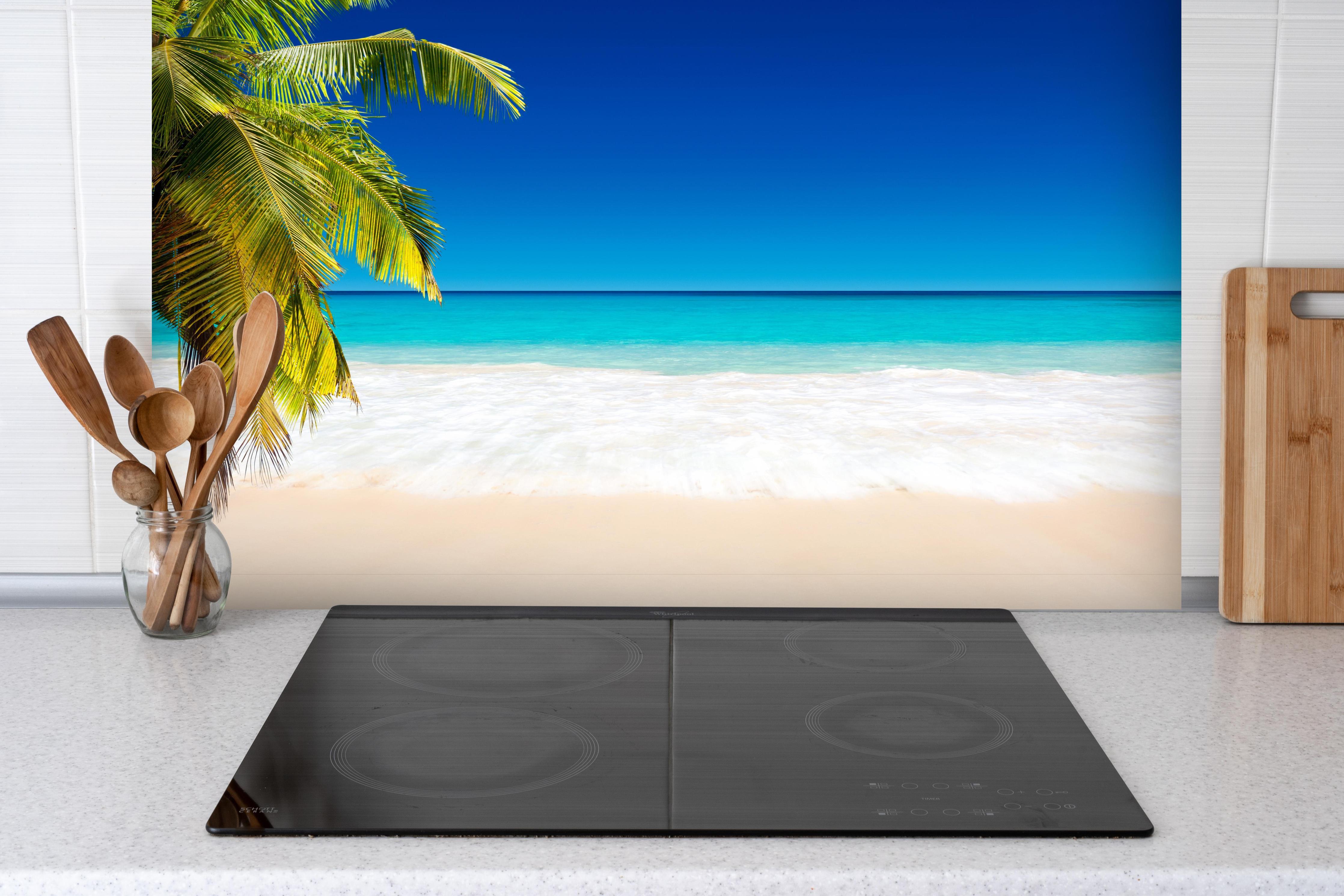 Spritzschutz - Seychellen Strand hinter einem Cerankochfeld zwischen Holz-Kochutensilien
