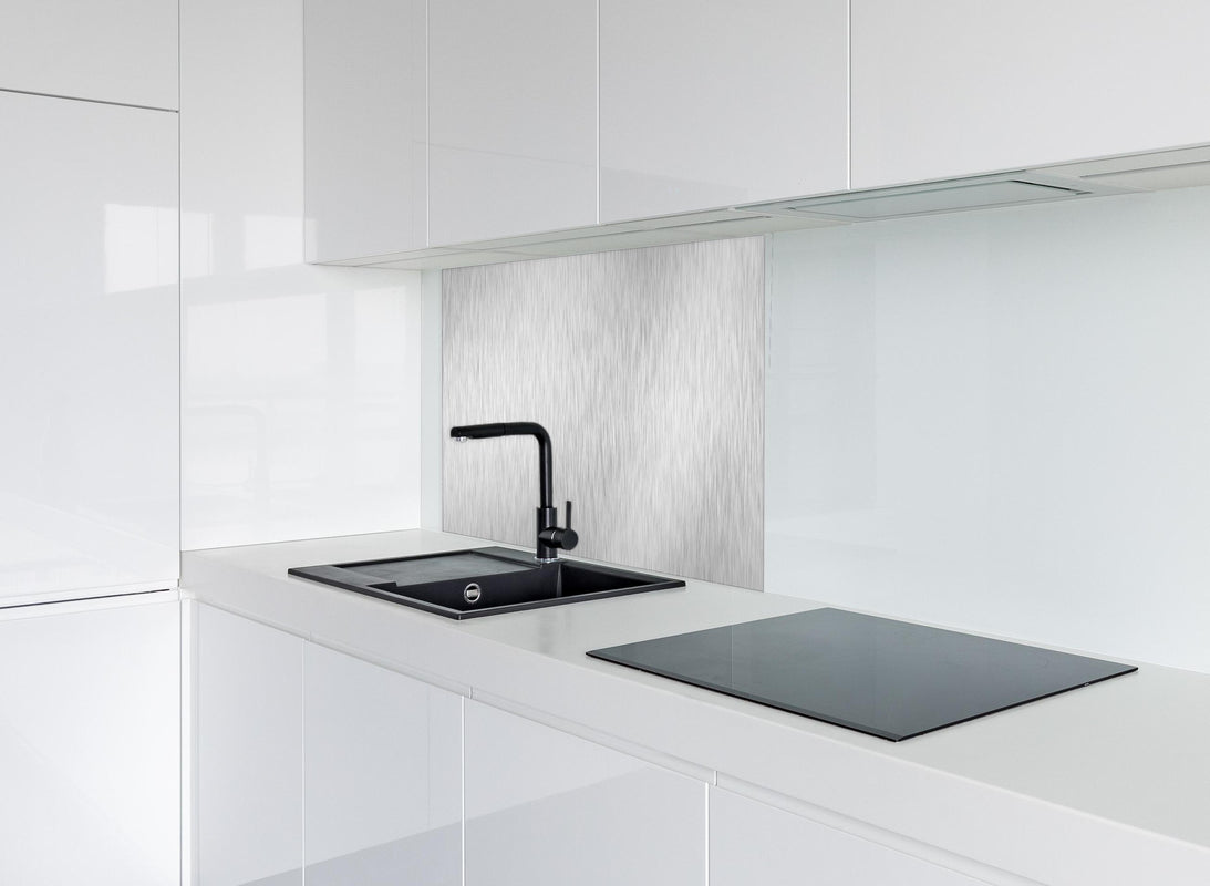Spritzschutz - Silberne belichtete Oberfläche hinter modernem schwarz-matten Spülbecken in weißer Hochglanz-Küche