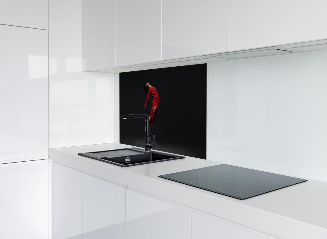 Spritzschutz - Springende Zeitgenössische Tänzerin  hinter modernem schwarz-matten Spülbecken in weißer Hochglanz-Küche
