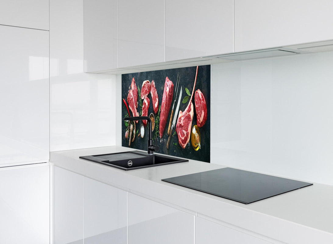 Spritzschutz - Steakvariationen auf Schieferplatte hinter modernem schwarz-matten Spülbecken in weißer Hochglanz-Küche