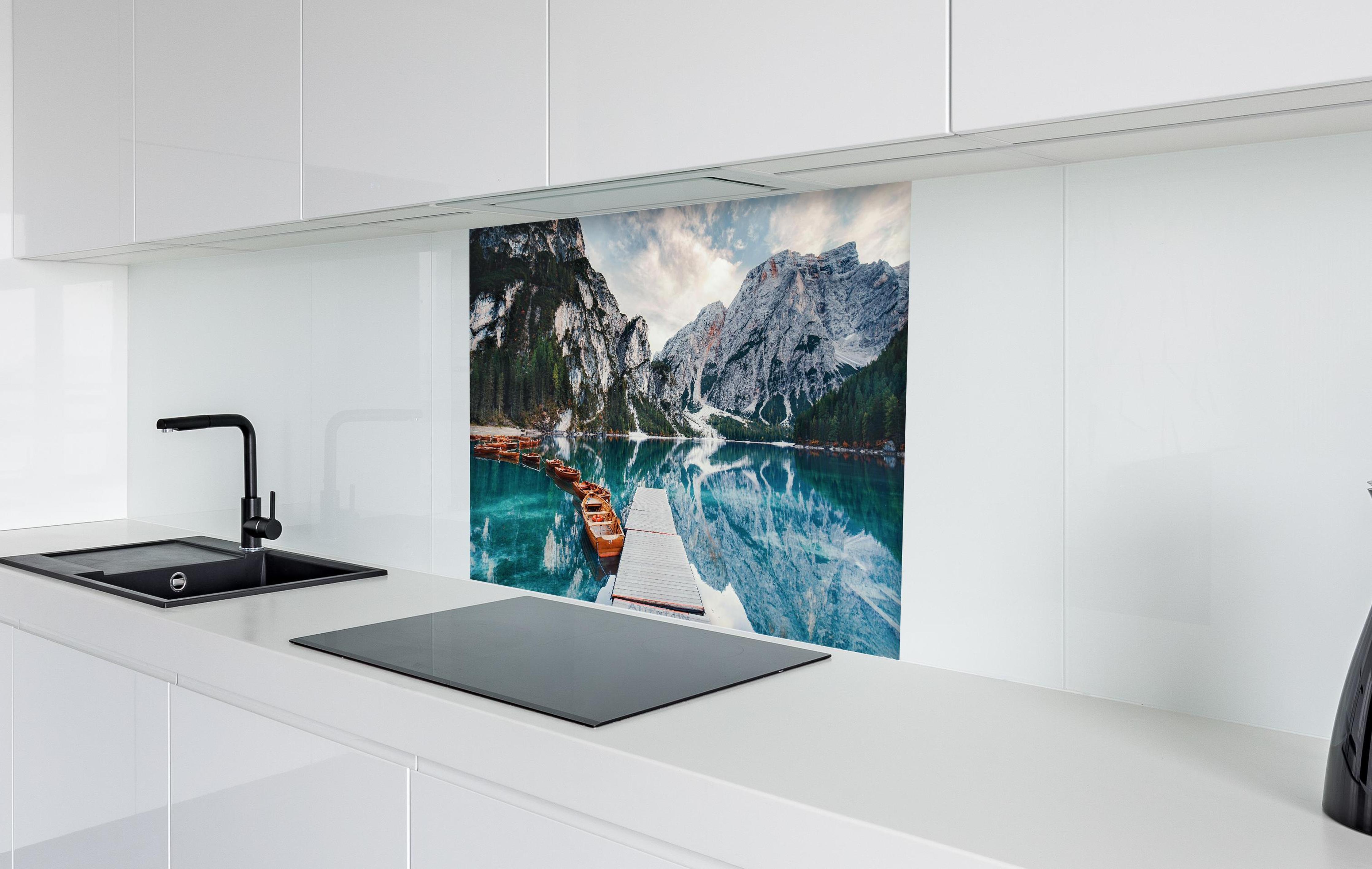 Spritzschutz - Steg am Bergsee mit Booten  in weißer Hochglanz-Küche hinter einem Cerankochfeld