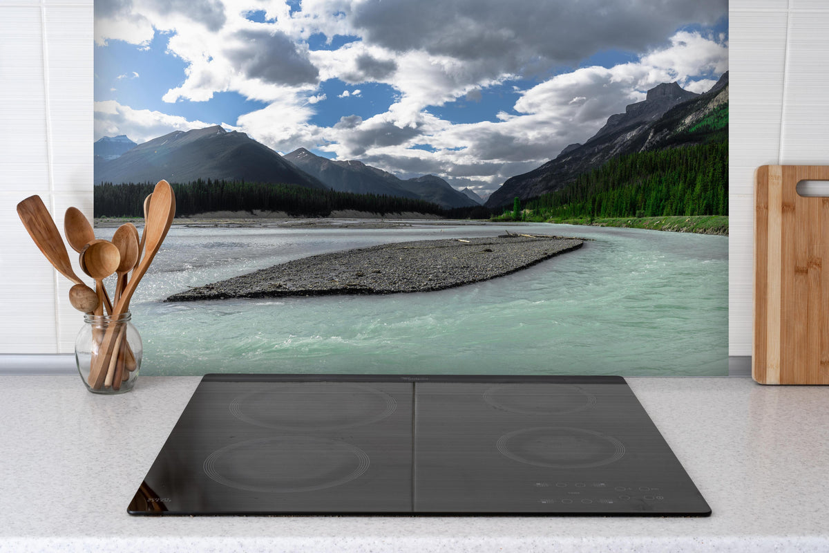 Spritzschutz - Steinlandschaft auf dem Wasser in Banff hinter einem Cerankochfeld zwischen Holz-Kochutensilien
