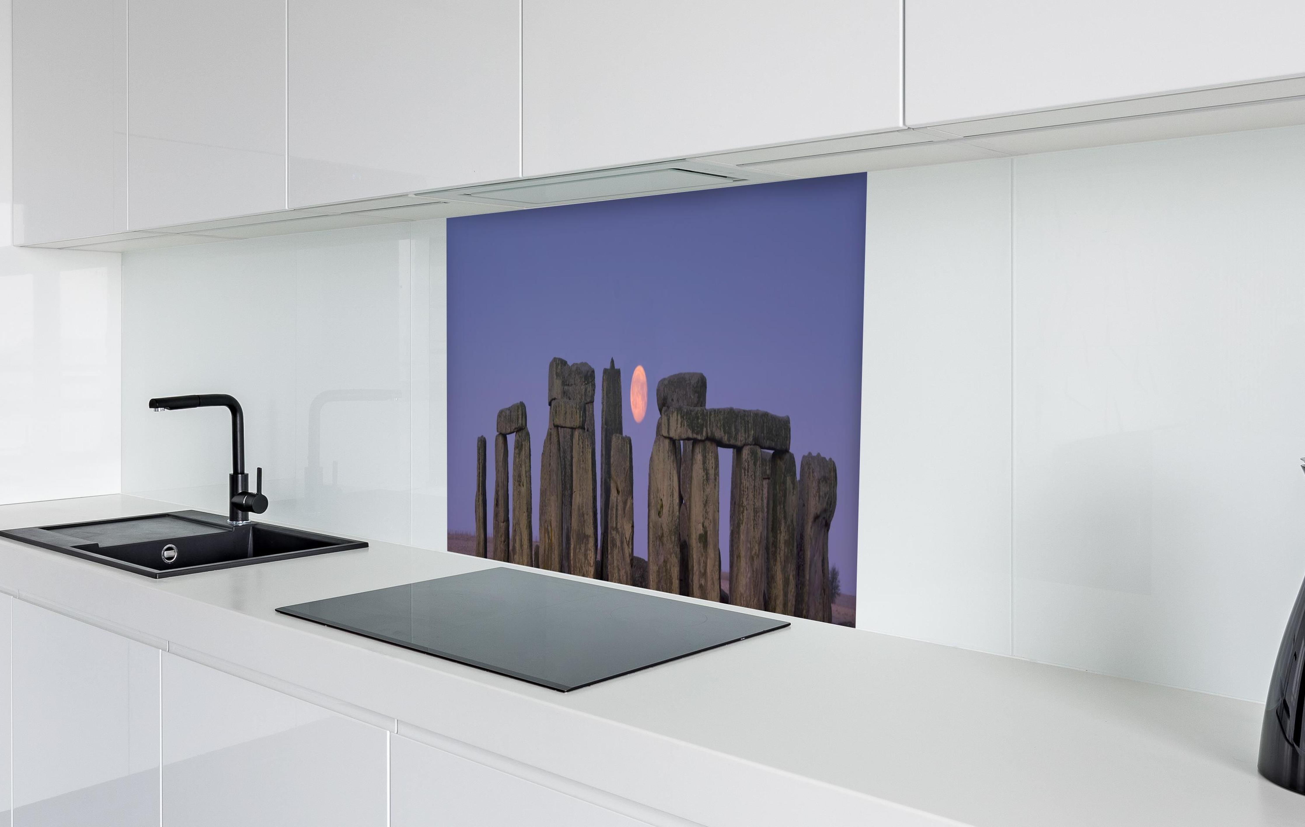 Spritzschutz - Stonehenge bei Nacht -  England  in weißer Hochglanz-Küche hinter einem Cerankochfeld