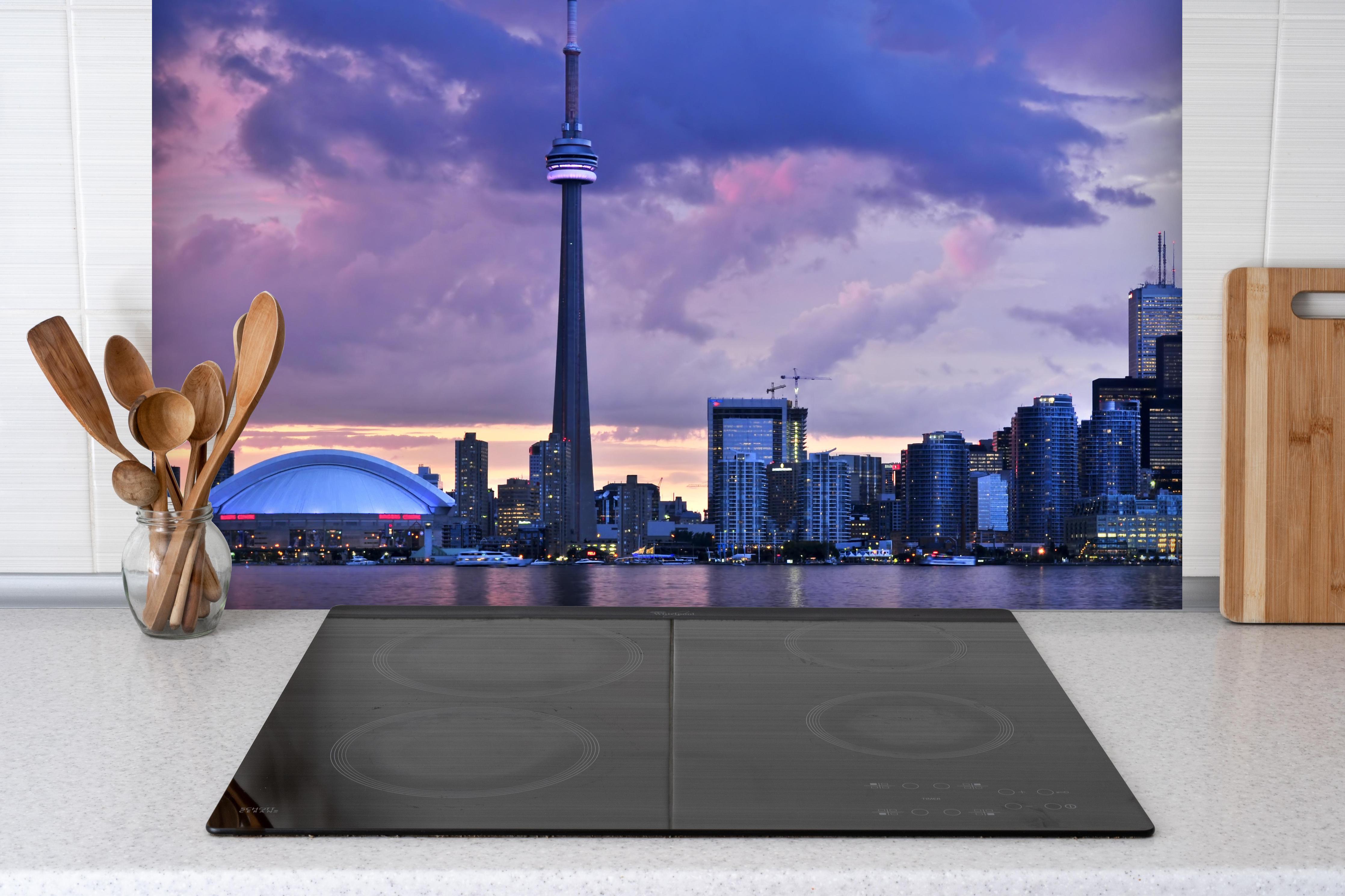 Spritzschutz - Toronto Skyline bei Abendlicht hinter einem Cerankochfeld zwischen Holz-Kochutensilien
