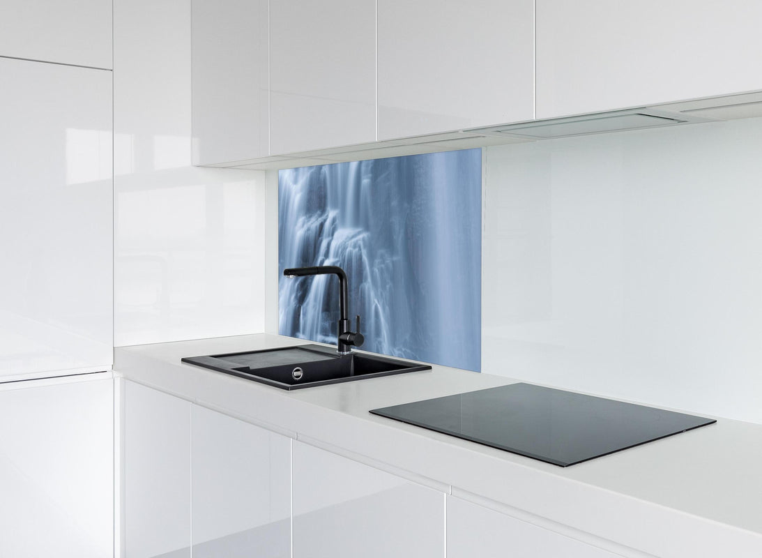 Spritzschutz - Traumartiger Wasserfall an Felsenwand hinter modernem schwarz-matten Spülbecken in weißer Hochglanz-Küche