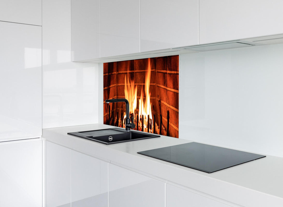 Spritzschutz - Warmes Kaminfeuer hinter modernem schwarz-matten Spülbecken in weißer Hochglanz-Küche