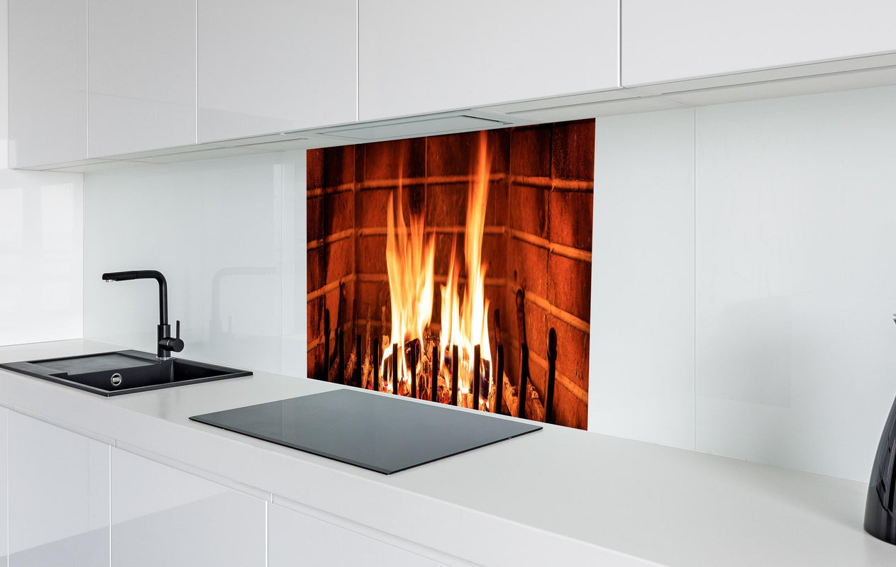 Spritzschutz - Warmes Kaminfeuer  in weißer Hochglanz-Küche hinter einem Cerankochfeld