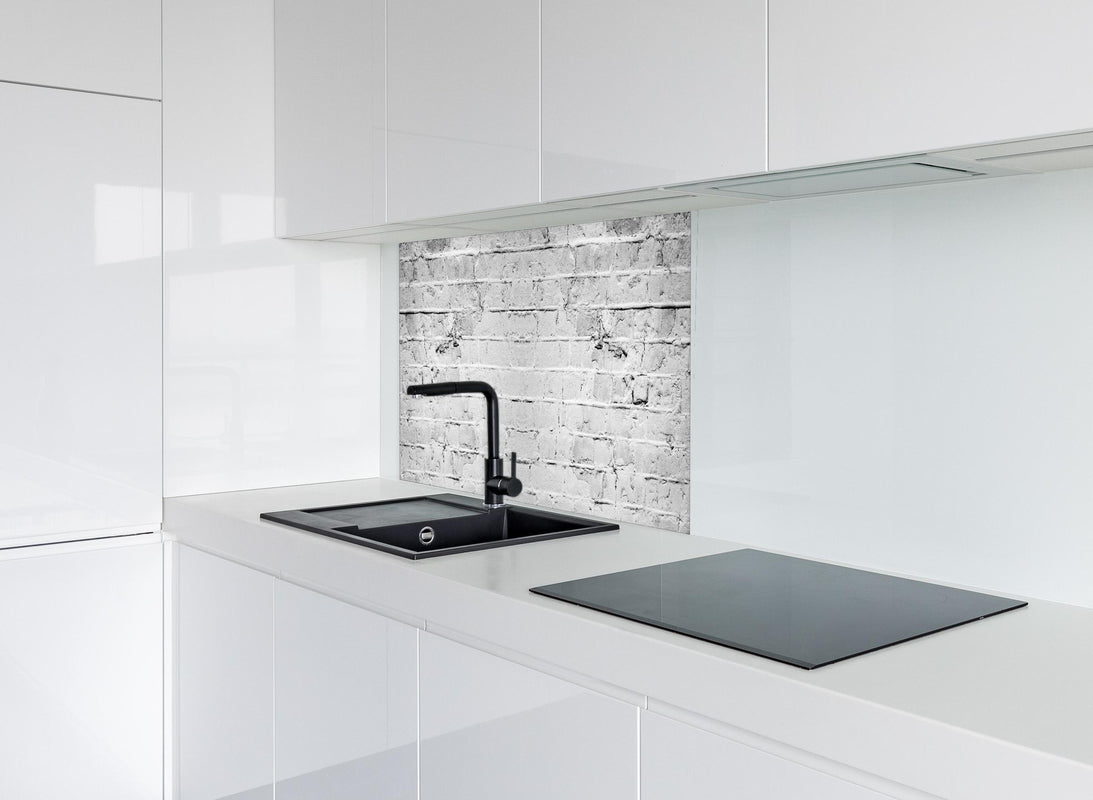 Spritzschutz - Weiß grau beschädigte Backstein Wand hinter modernem schwarz-matten Spülbecken in weißer Hochglanz-Küche