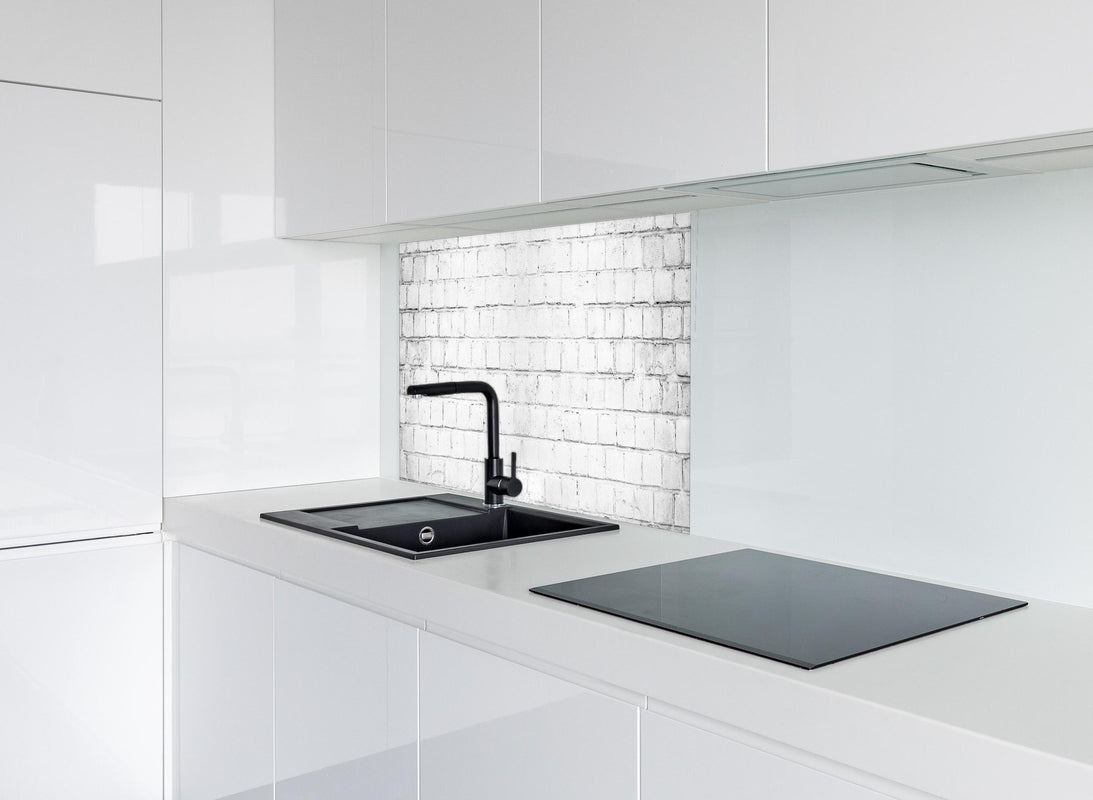 Spritzschutz - Weiße beschädigte Mauer hinter modernem schwarz-matten Spülbecken in weißer Hochglanz-Küche
