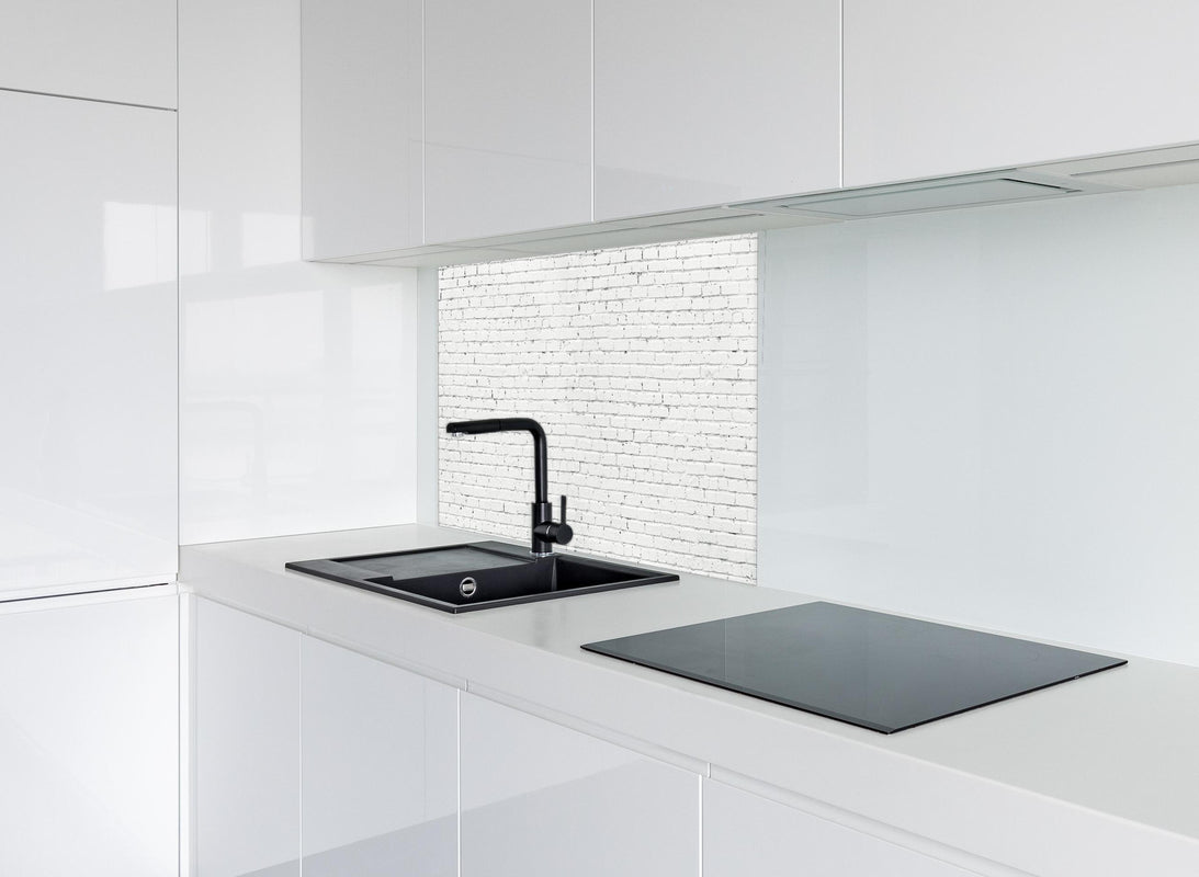Spritzschutz - Weiße lange Backsteinfassade hinter modernem schwarz-matten Spülbecken in weißer Hochglanz-Küche