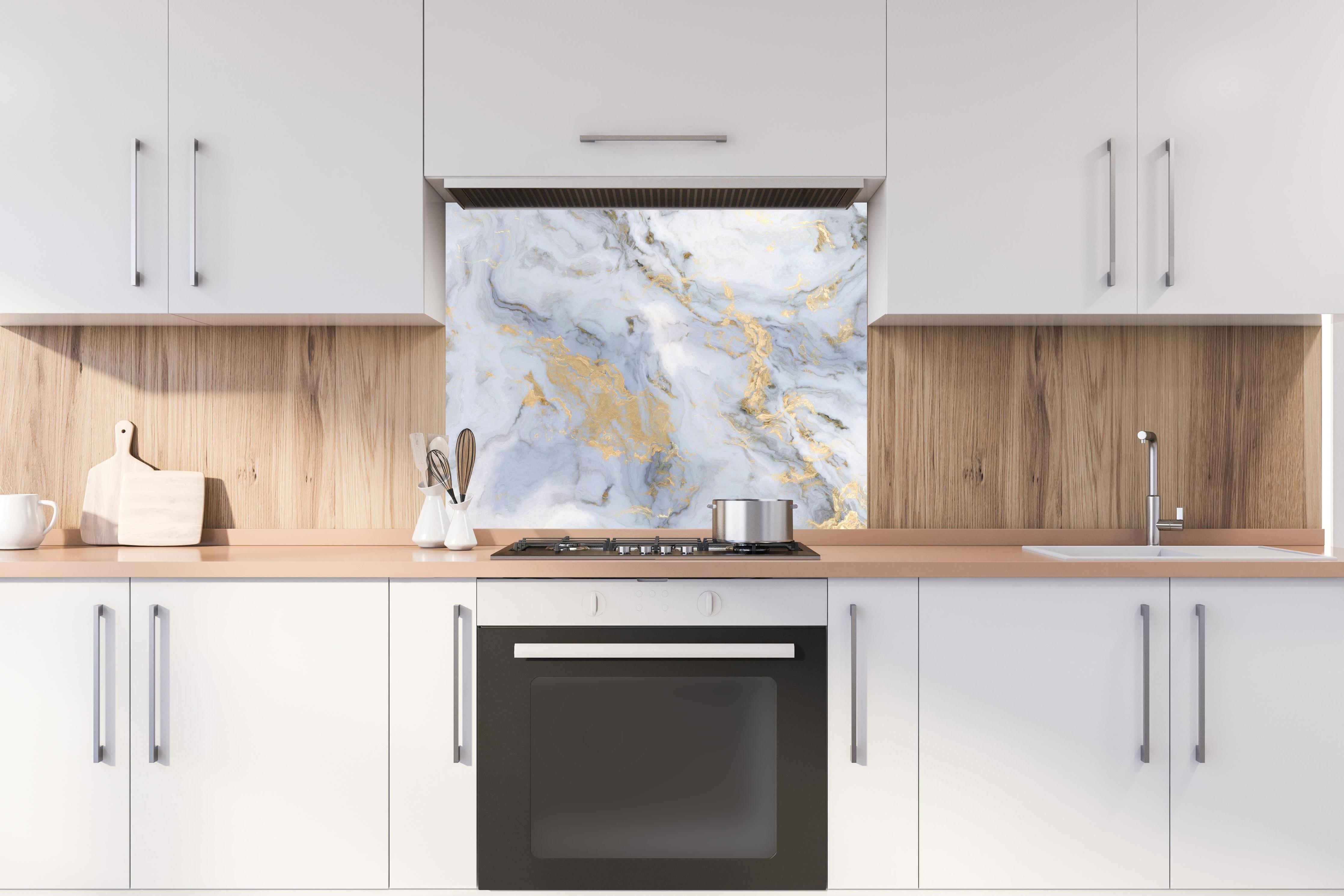 Spritzschutz - Weißer Marmor mit Goldelementen hinter stilvollem Gasherd unter Dunstabzugshaube