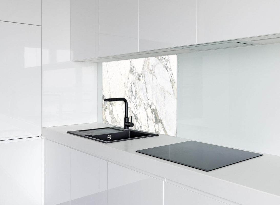 Spritzschutz - Weißer brüchiger Marmor hinter modernem schwarz-matten Spülbecken in weißer Hochglanz-Küche
