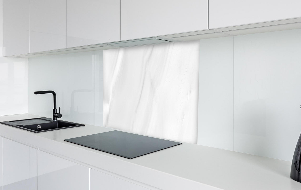 Spritzschutz - Weißer polierter Marmor  in weißer Hochglanz-Küche hinter einem Cerankochfeld
