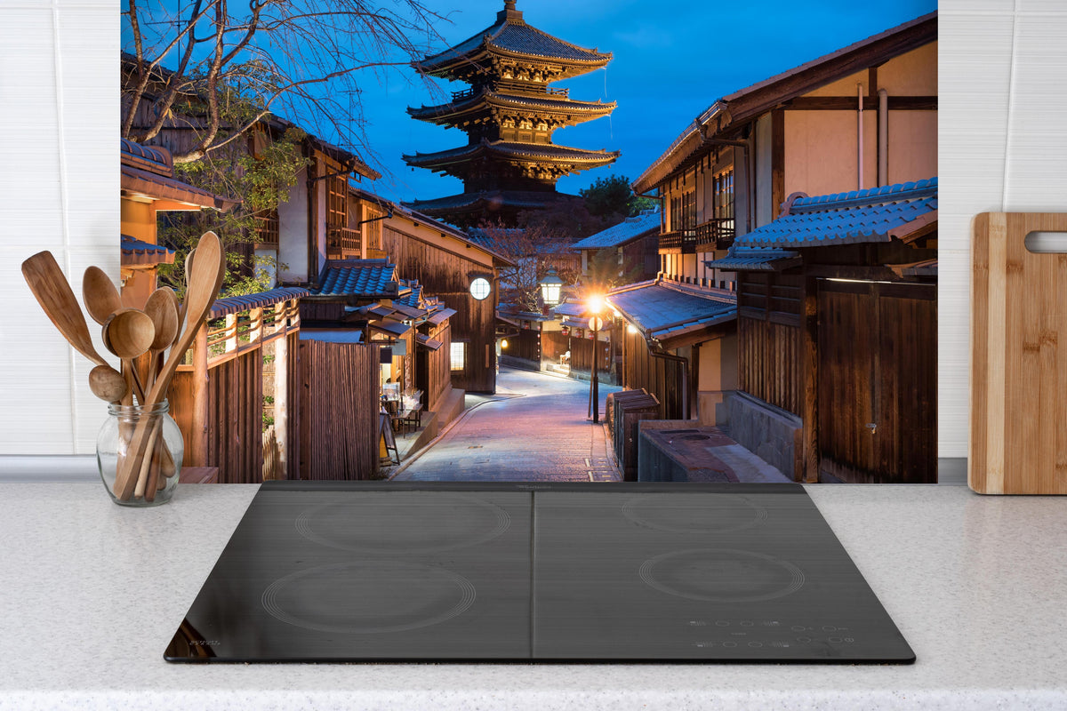 Spritzschutz - Yasaka-Pagode bei Nacht in Kyoto hinter einem Cerankochfeld zwischen Holz-Kochutensilien
