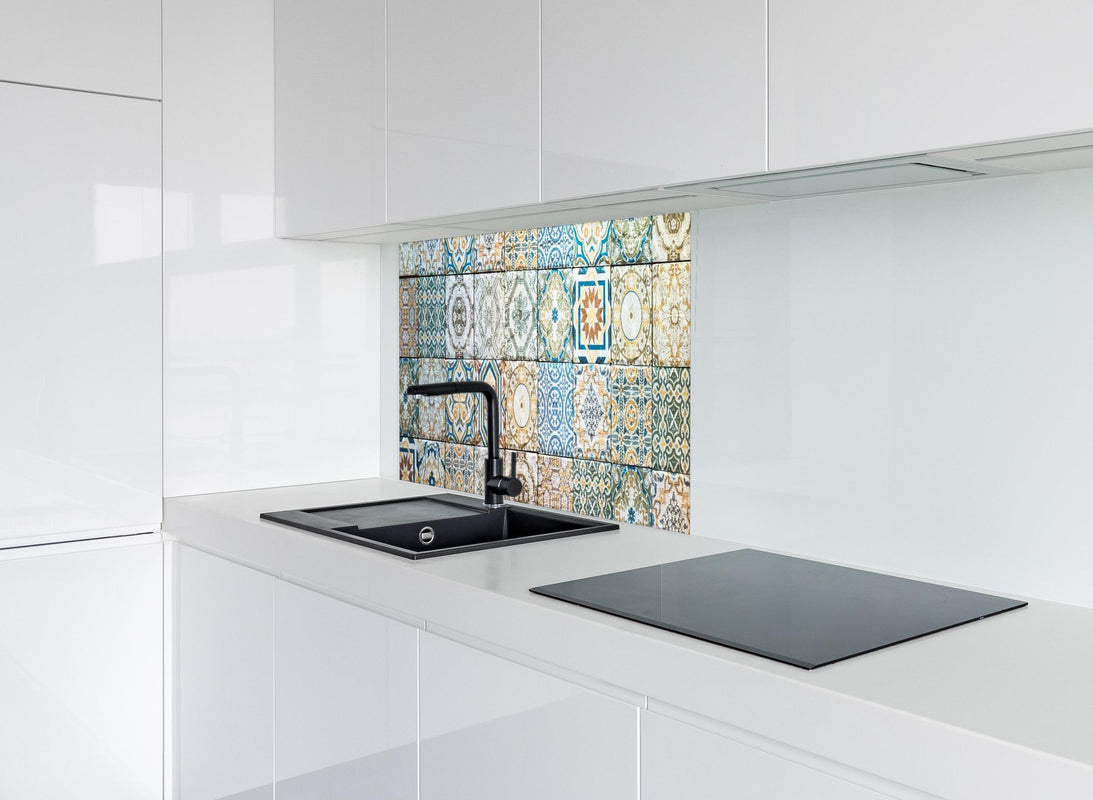 Spritzschutz - buntes Mosaik im spanischen Stil hinter modernem schwarz-matten Spülbecken in weißer Hochglanz-Küche