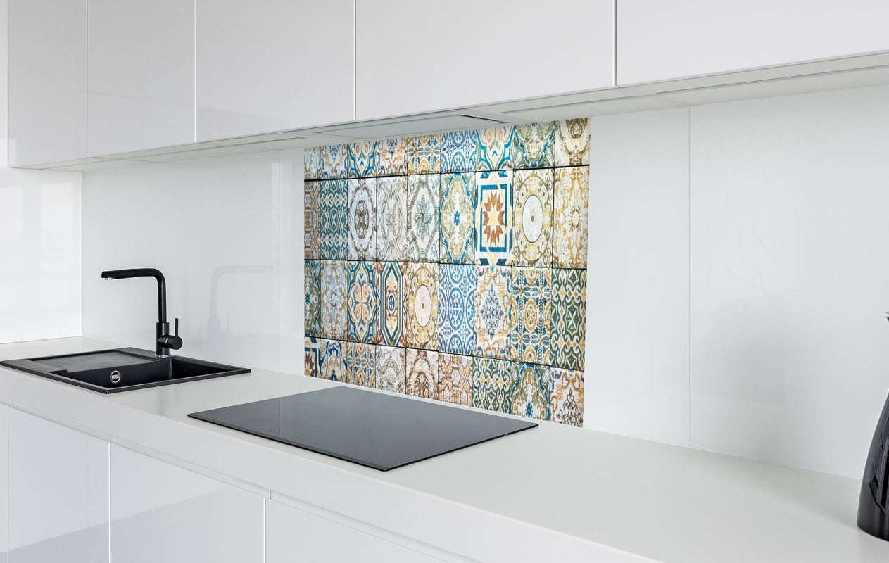Spritzschutz - buntes Mosaik im spanischen Stil  in weißer Hochglanz-Küche hinter einem Cerankochfeld