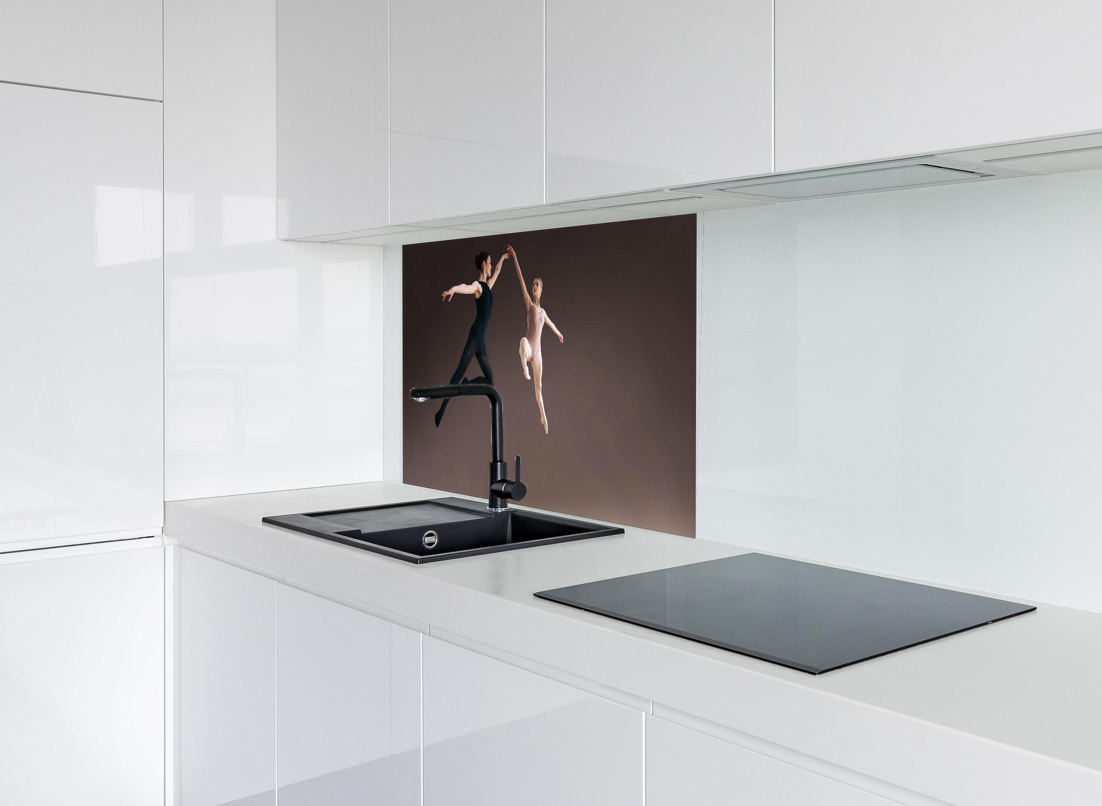 Spritzschutz - zwei Balletttänzerinnen hoch in der Luft hinter einem Cerankochfeld zwischen Holz-Kochutensilien
