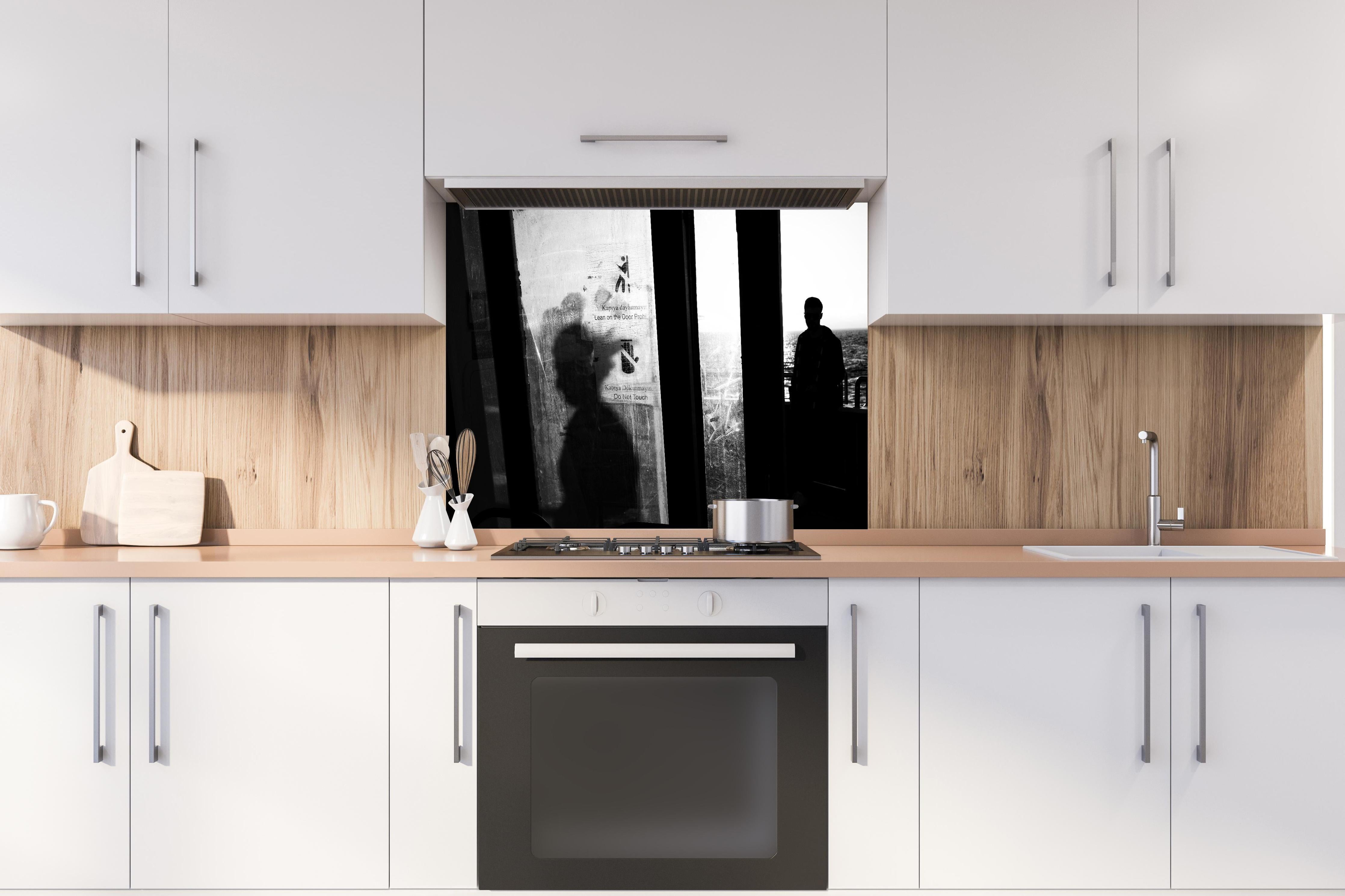 Spritzschutz - Städtisches Bild mit Silhouetten hinter einem Cerankochfeld zwischen Holz-Kochutensilien
