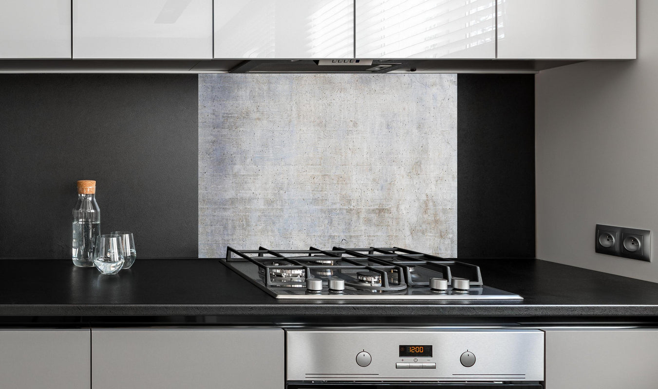 Spritzschutz - Stilvolle grau-weiße Betonwand Textur hinter einem Cerankochfeld zwischen Holz-Kochutensilien
