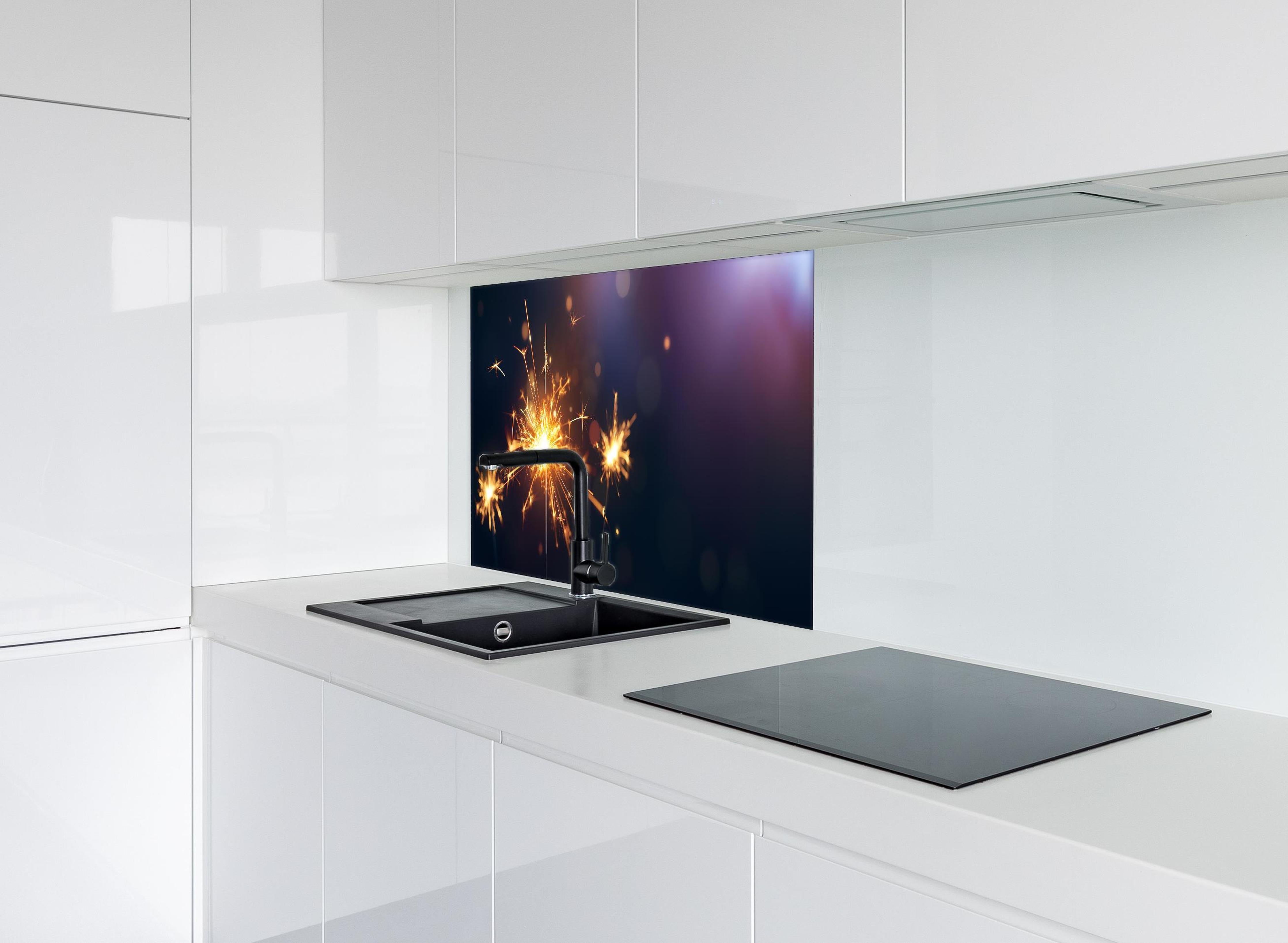 Spritzschutz - Strahlendes Wunderkerzen-Goldlichtfeuerwerk hinter einem Cerankochfeld zwischen Holz-Kochutensilien
