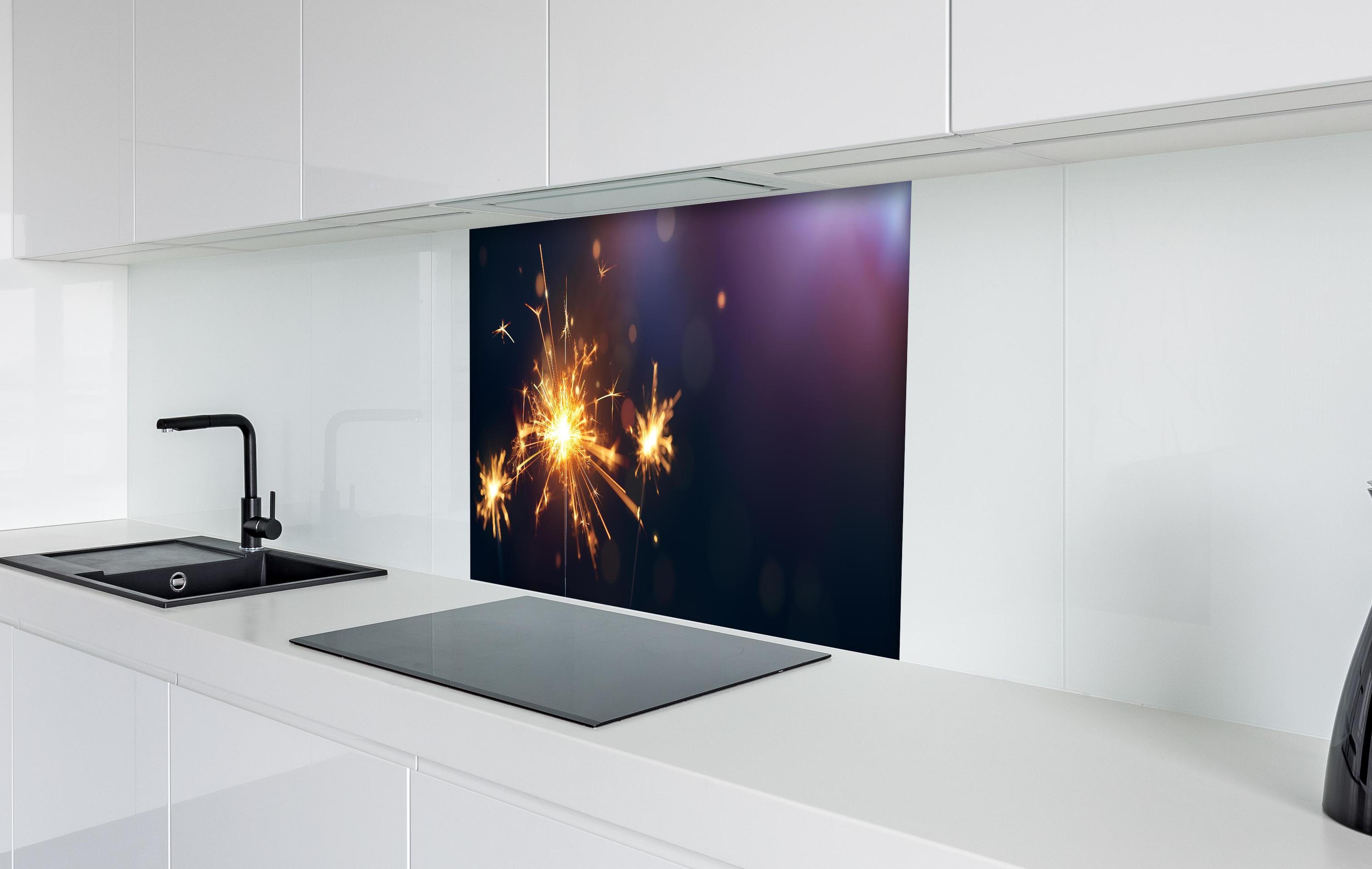 Spritzschutz - Strahlendes Wunderkerzen-Goldlichtfeuerwerk hinter einem Cerankochfeld zwischen Holz-Kochutensilien
