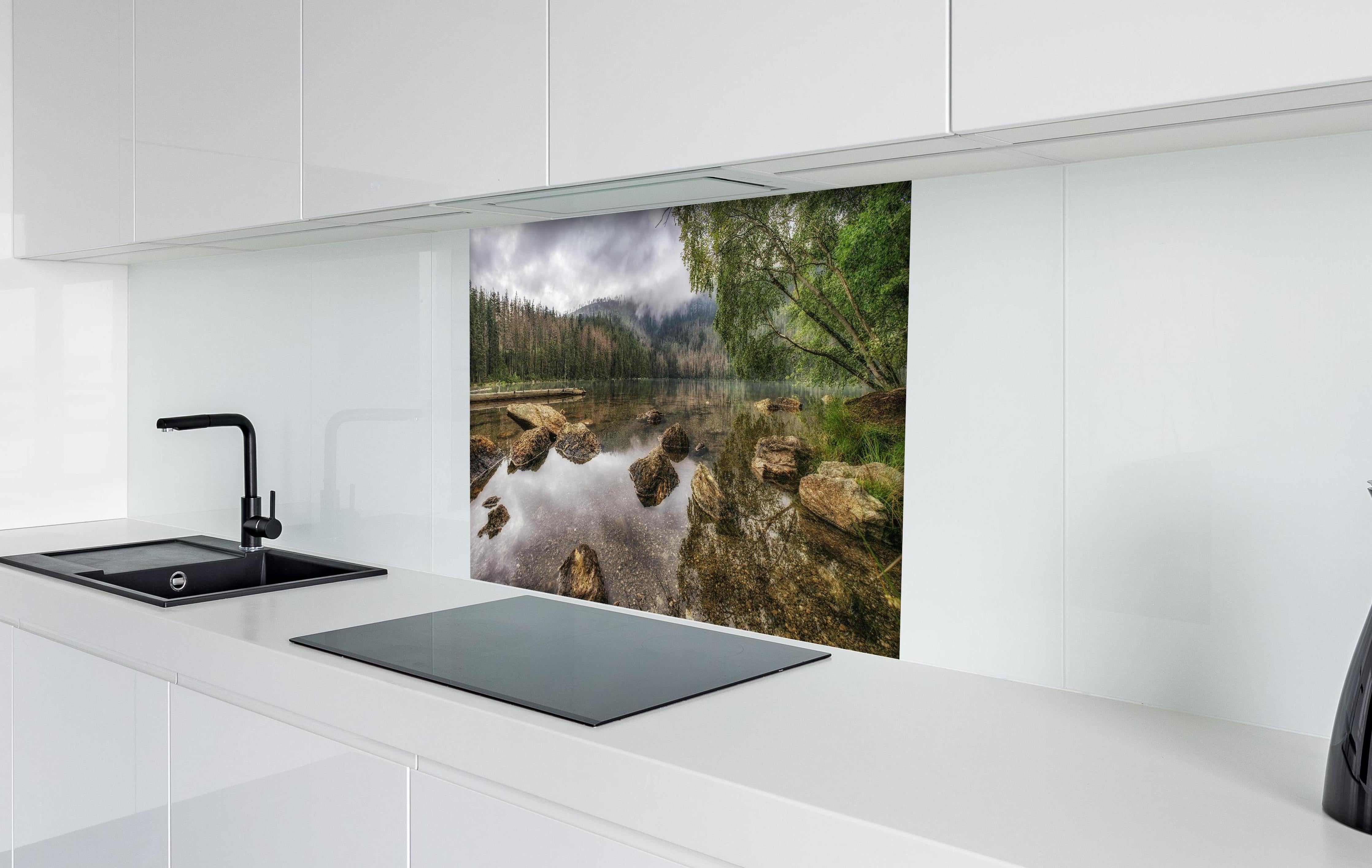 Spritzschutz - Sumava - Schwarzer See - Tschechische Republik hinter einem Cerankochfeld zwischen Holz-Kochutensilien
