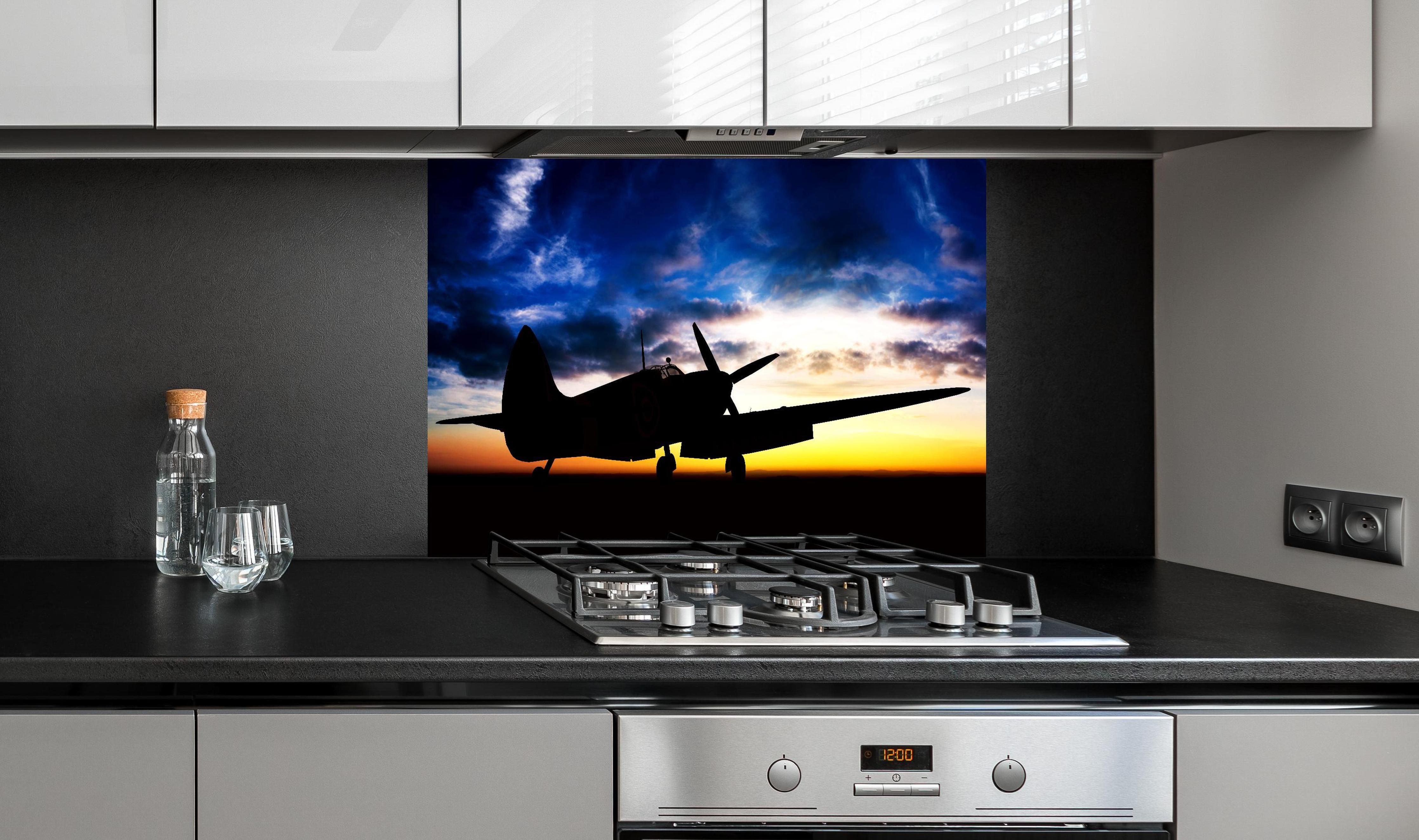 Spritzschutz - Supermarine Spitfire hinter einem Cerankochfeld zwischen Holz-Kochutensilien
