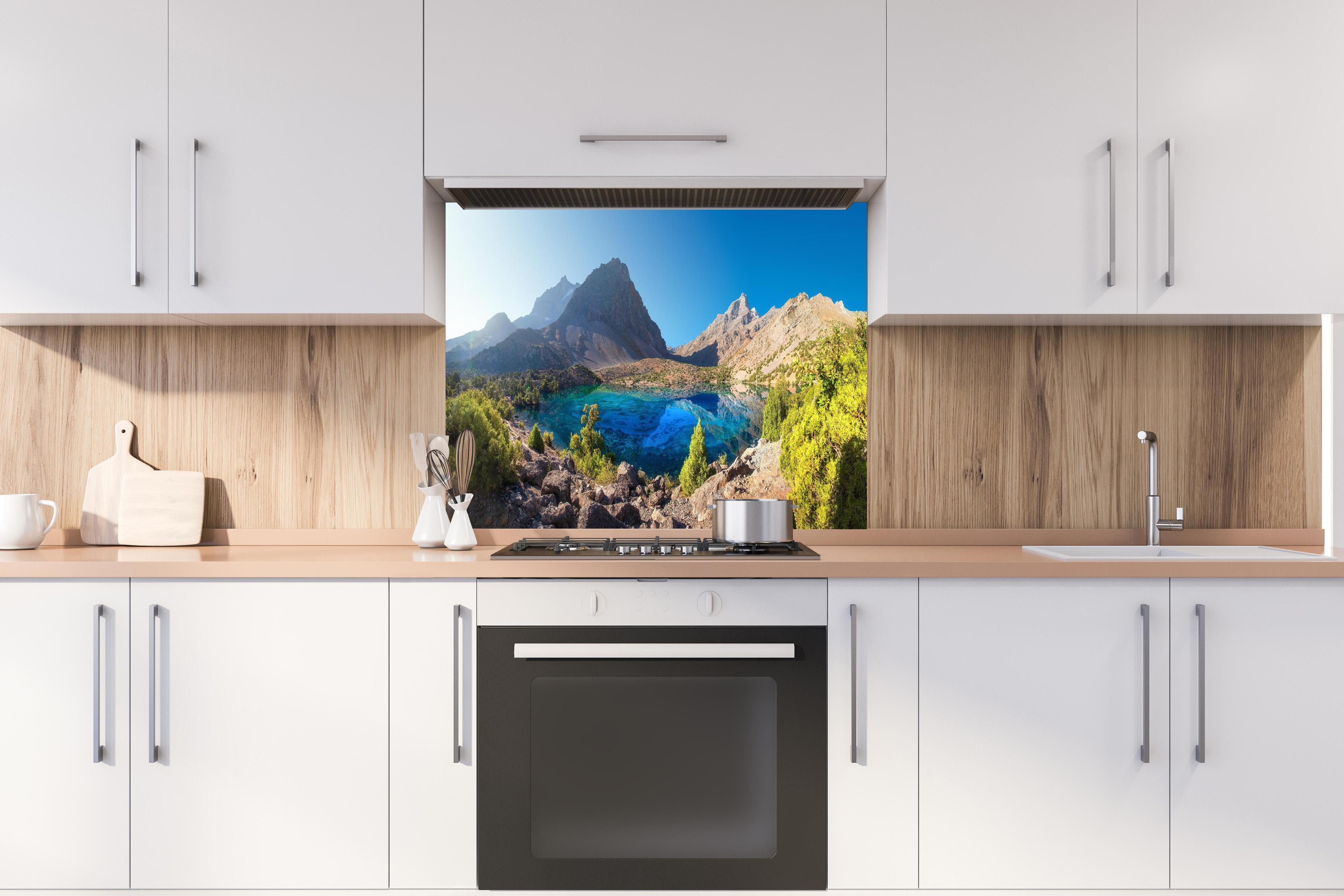 Spritzschutz - Tadschikistan See hinter einem Cerankochfeld zwischen Holz-Kochutensilien
