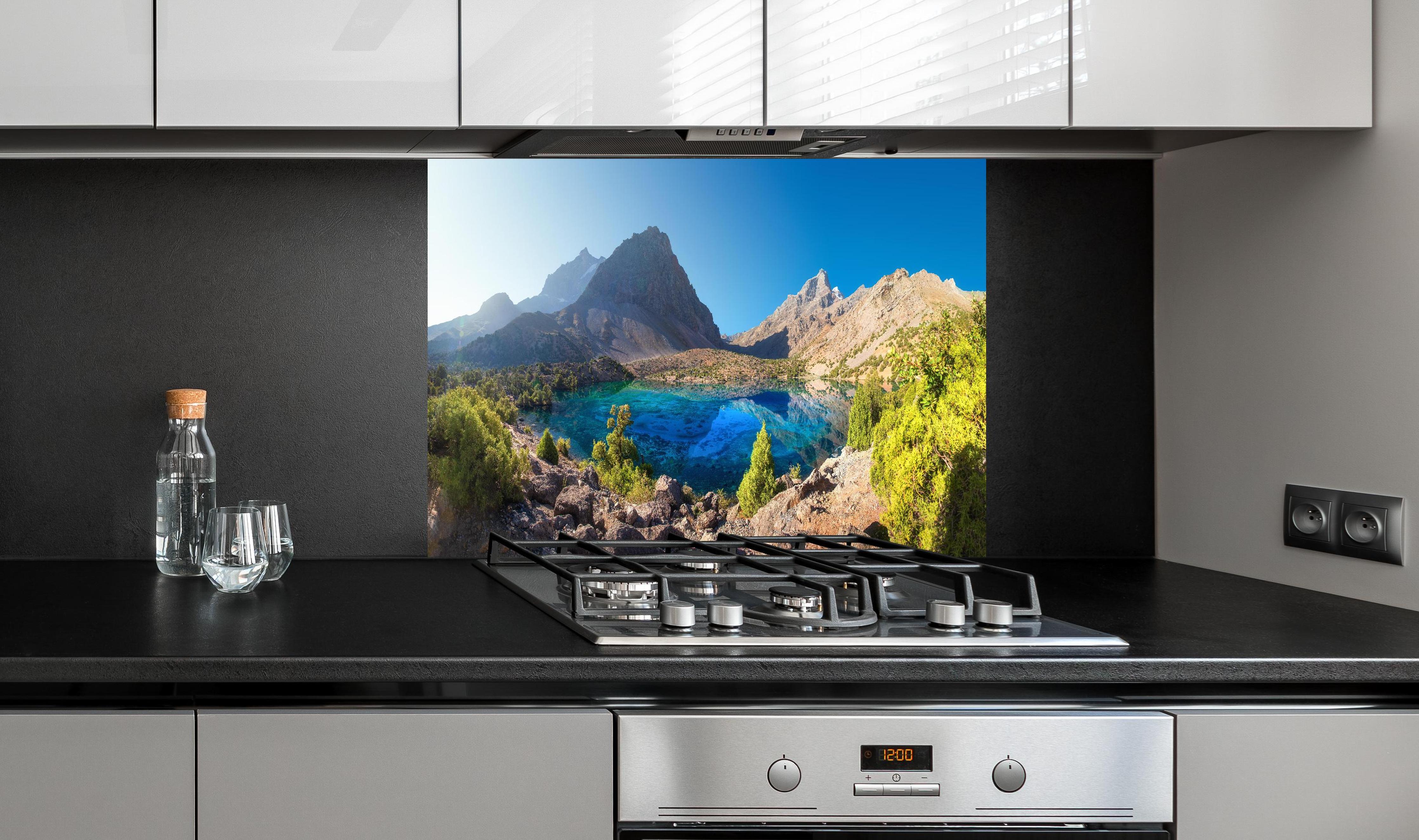 Spritzschutz - Tadschikistan See hinter einem Cerankochfeld zwischen Holz-Kochutensilien
