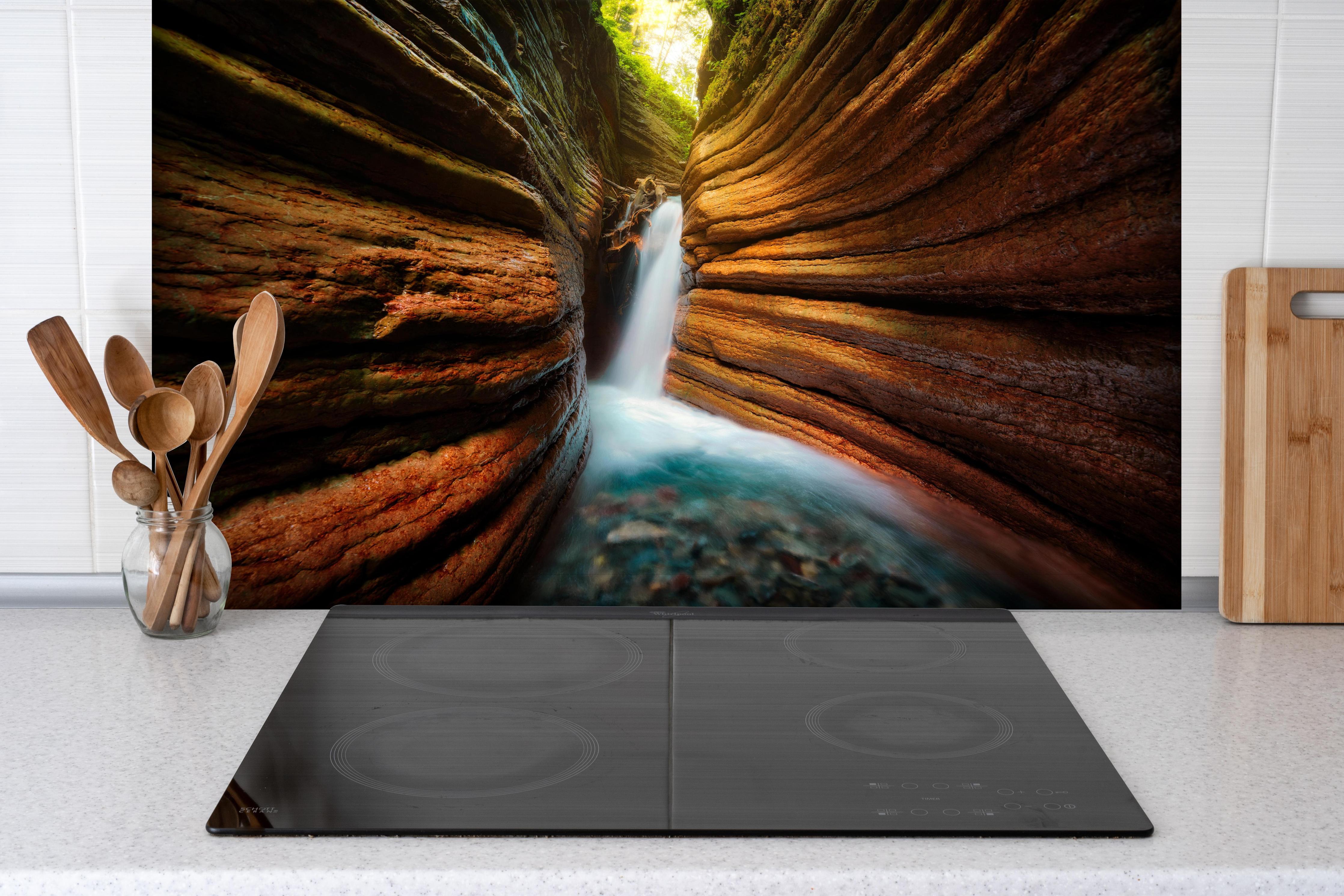 Spritzschutz - Tauglebach Klamm Slot Canyon River in Austria hinter einem Cerankochfeld zwischen Holz-Kochutensilien
