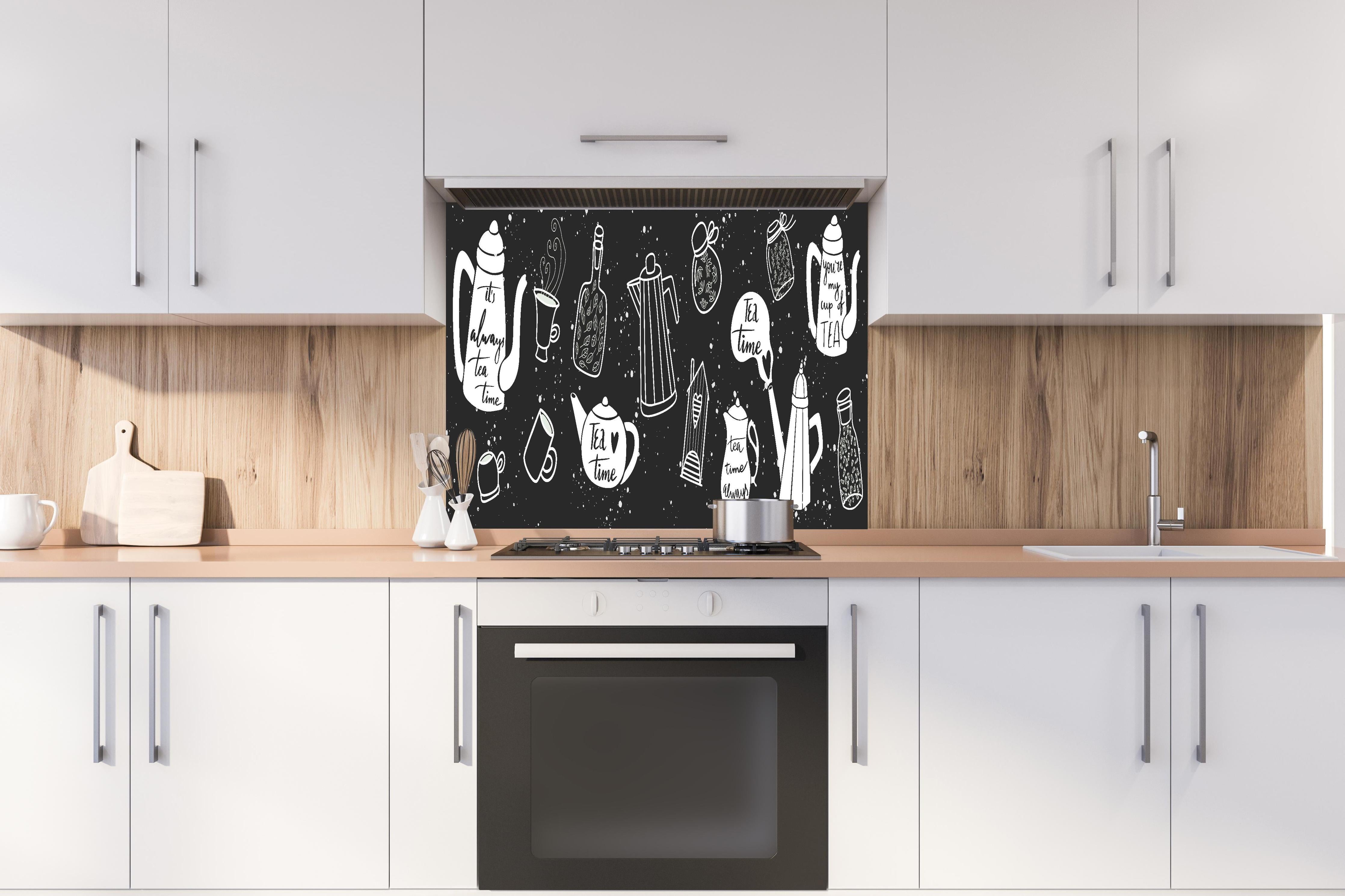 Spritzschutz - Tee Liebhaber Schwarz-Weiß Design Set hinter einem Cerankochfeld zwischen Holz-Kochutensilien
