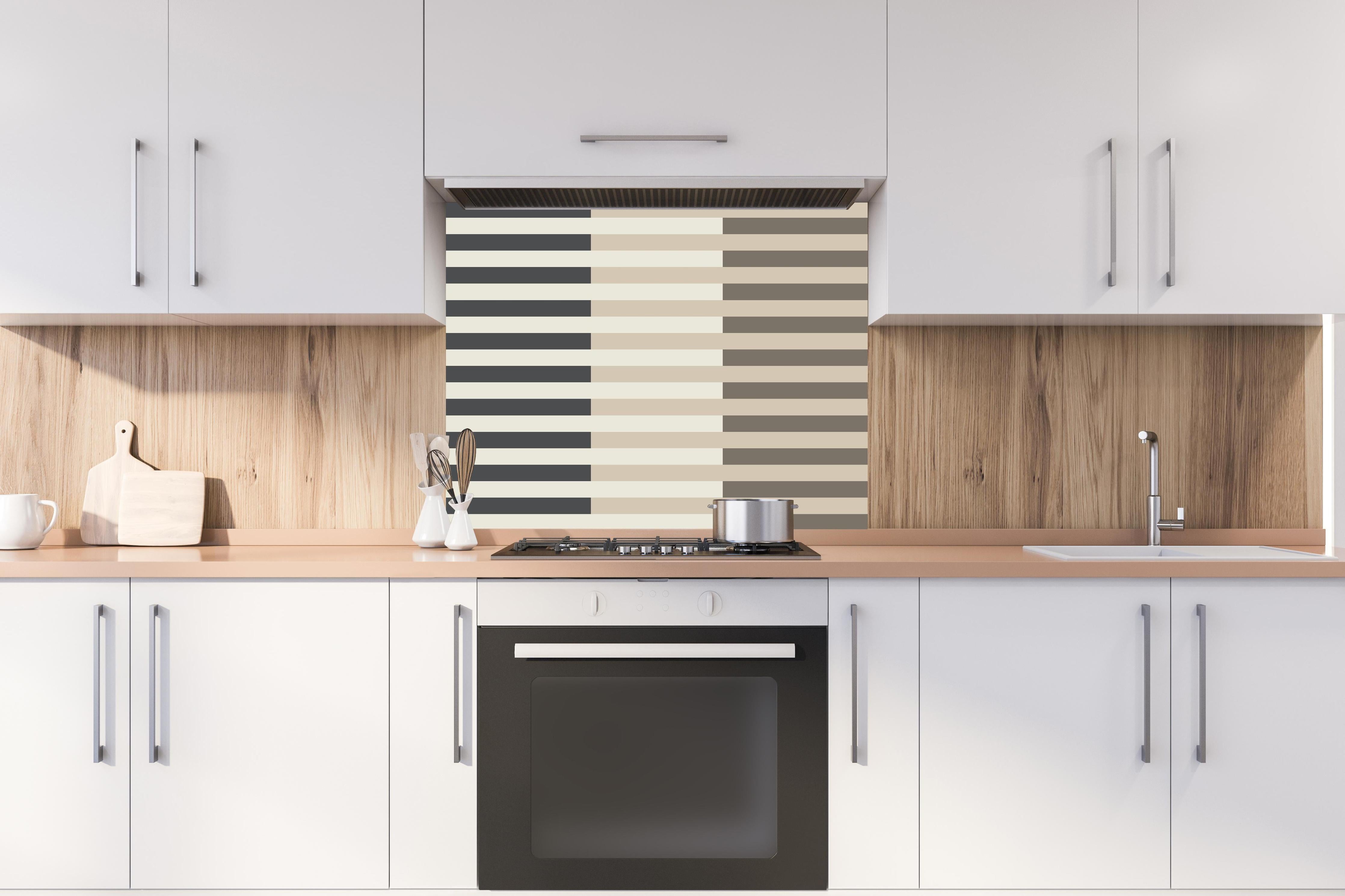 Spritzschutz - The Nudes - Multy Stripes - Toffee hinter einem Cerankochfeld zwischen Holz-Kochutensilien
