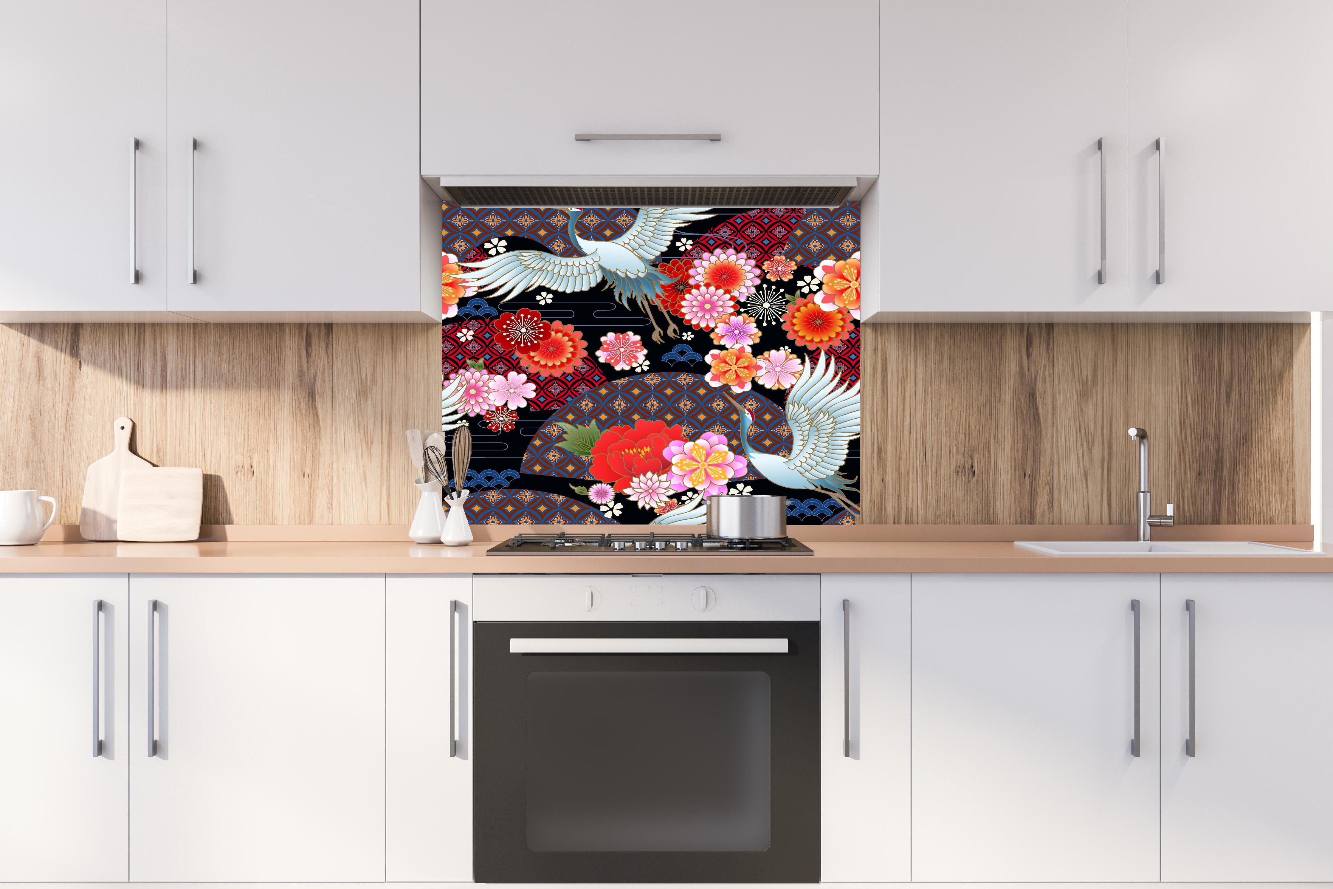 Spritzschutz - Traditionelles Muster mit Vögeln und Blumen hinter einem Cerankochfeld zwischen Holz-Kochutensilien
