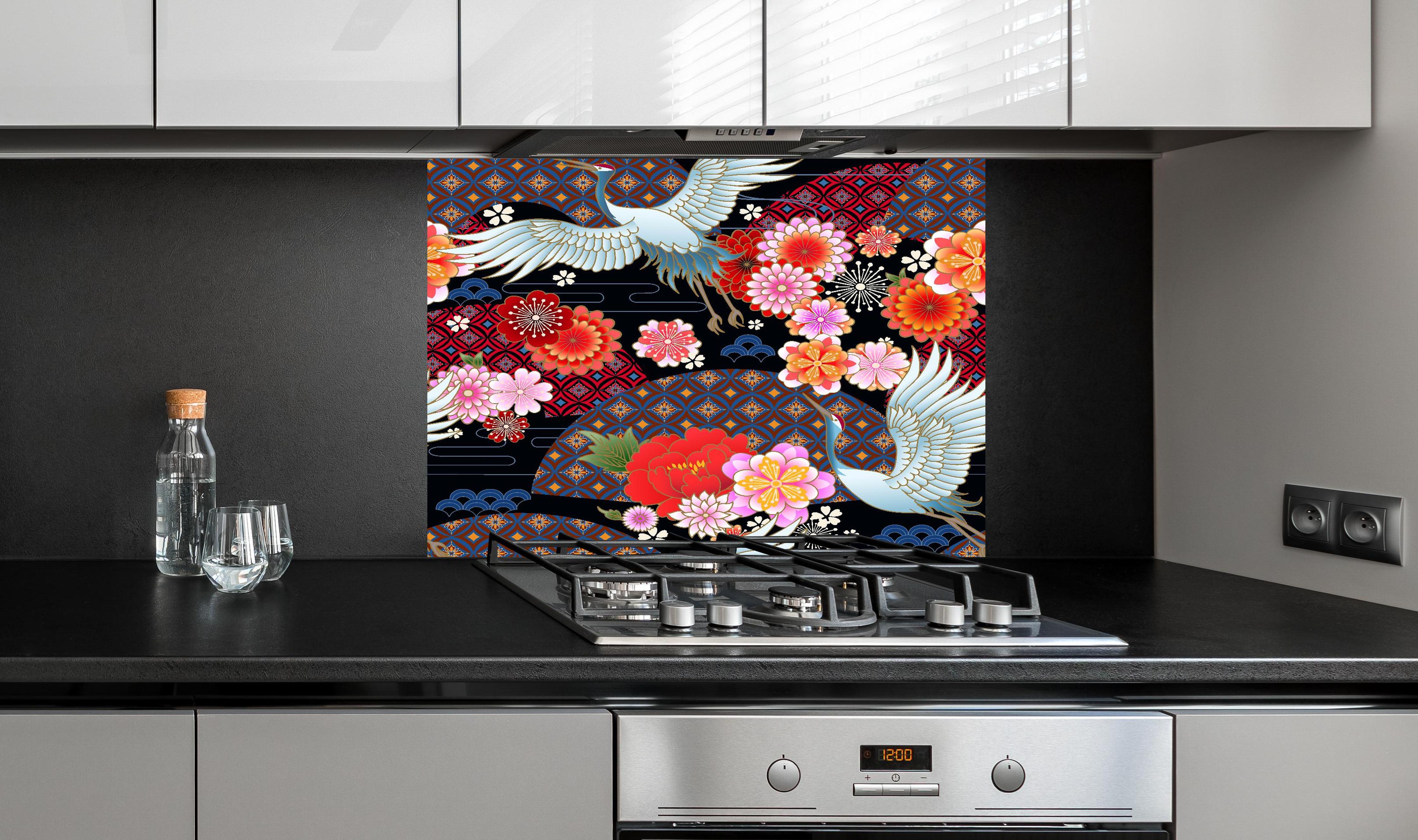 Spritzschutz - Traditionelles Muster mit Vögeln und Blumen hinter einem Cerankochfeld zwischen Holz-Kochutensilien
