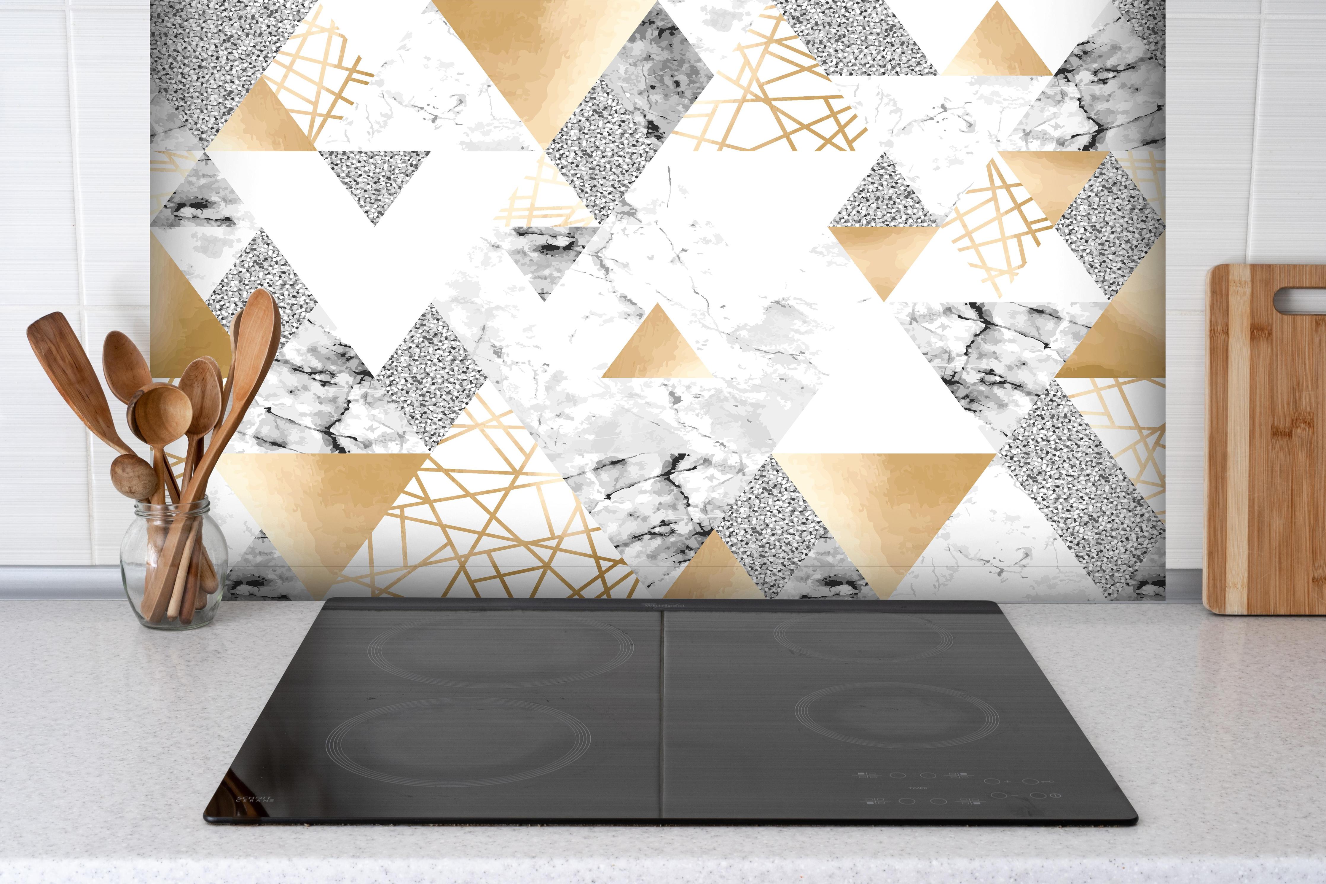 Spritzschutz - Trendige Gold Weiß Graue Dreiecksmuster Tapete hinter einem Cerankochfeld zwischen Holz-Kochutensilien
