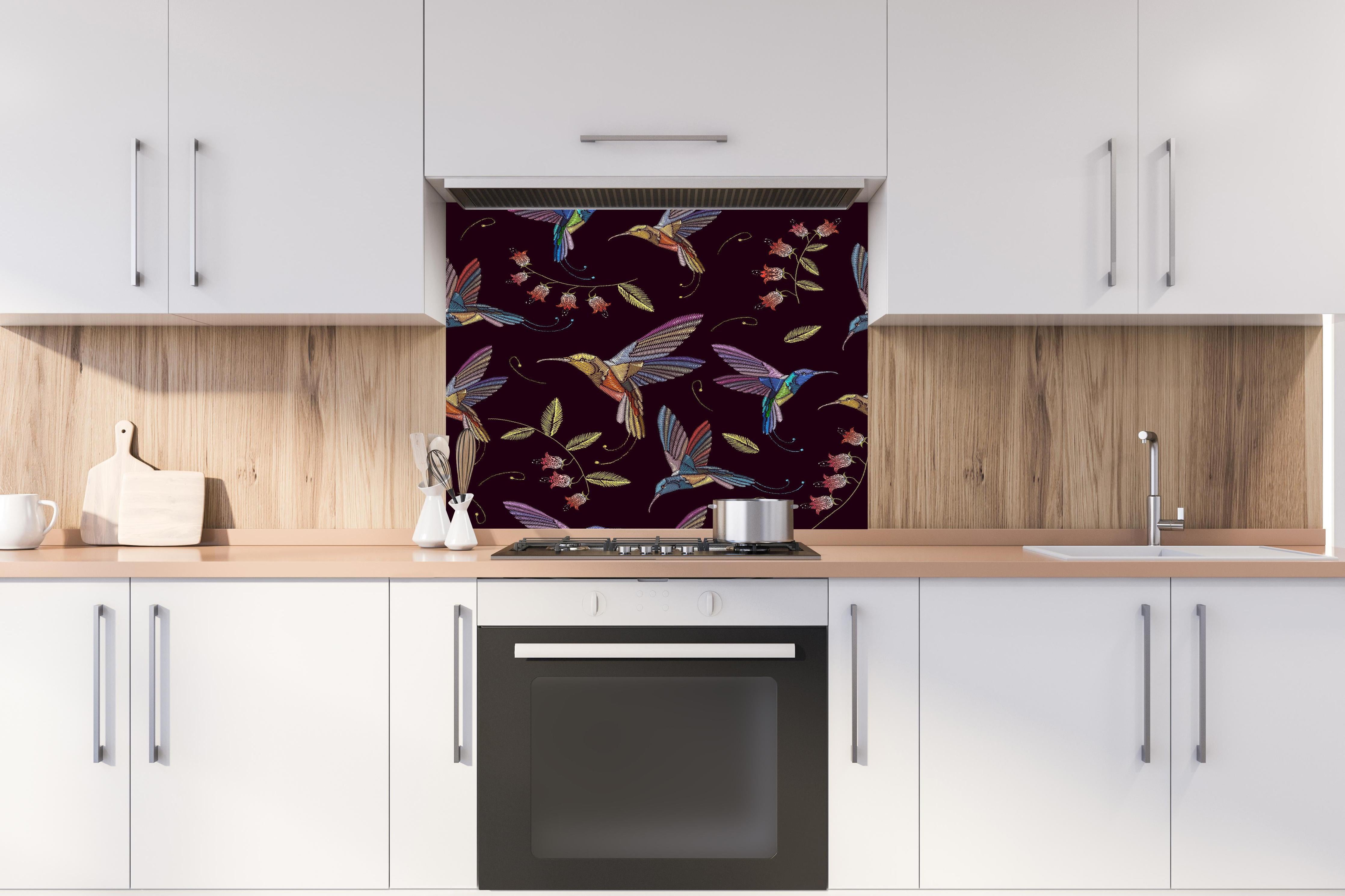 Spritzschutz - Tropische Kolibri-Blumen-Stickerei hinter einem Cerankochfeld zwischen Holz-Kochutensilien
