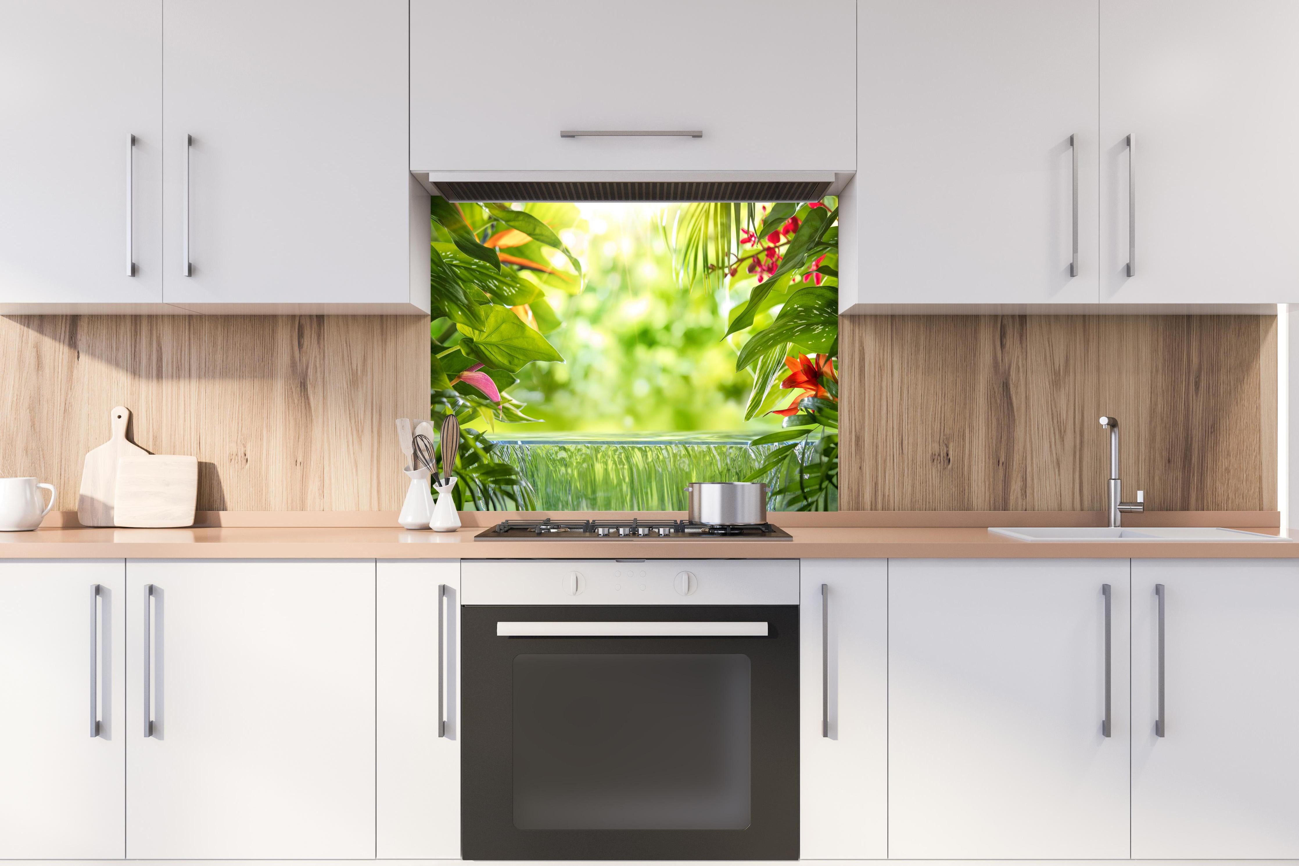 Spritzschutz - Tropische Palmenblätter im Amazonas hinter einem Cerankochfeld zwischen Holz-Kochutensilien
