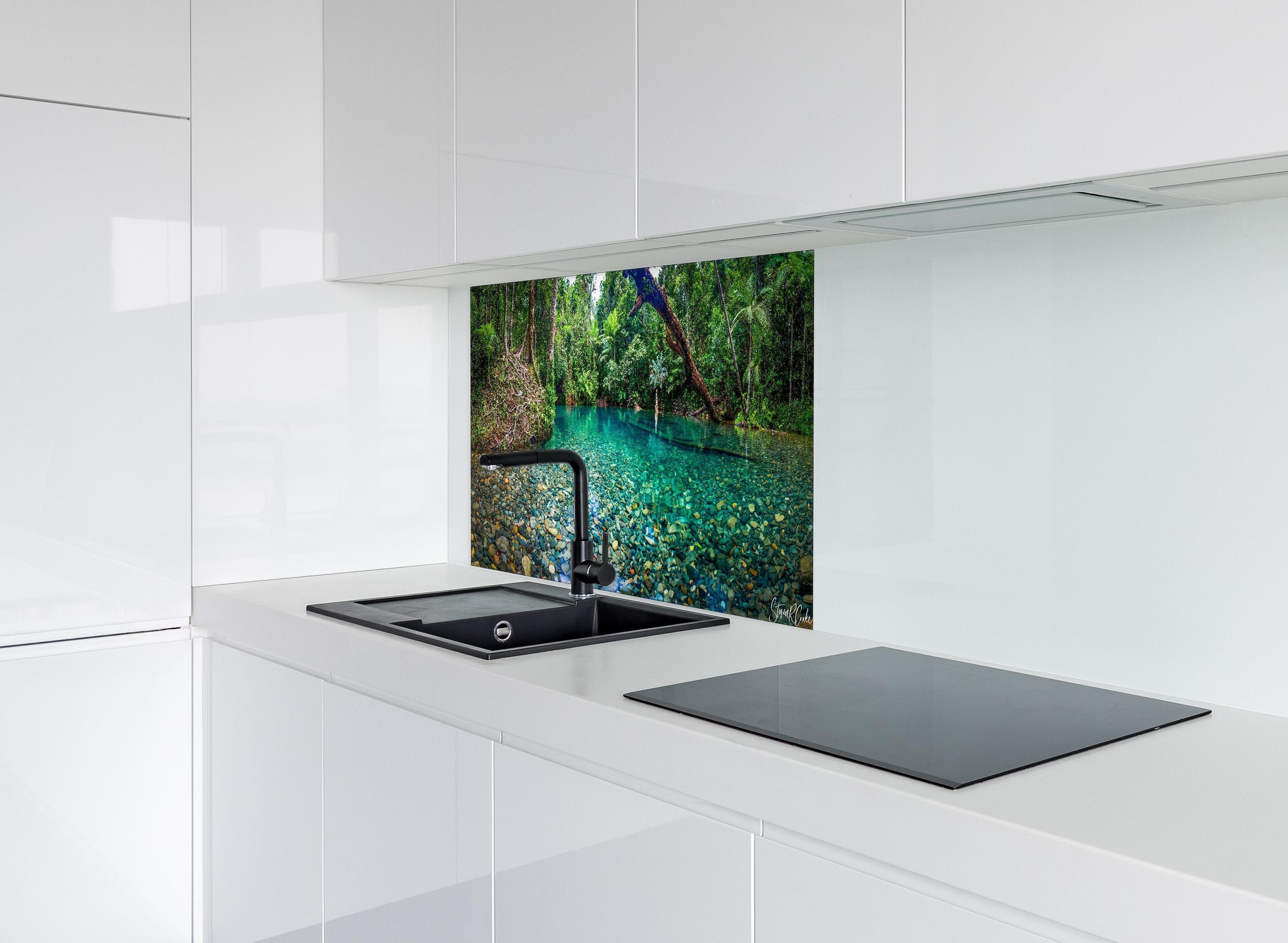 Spritzschutz - Tropischer Bach mit klarem Wasser hinter einem Cerankochfeld zwischen Holz-Kochutensilien
