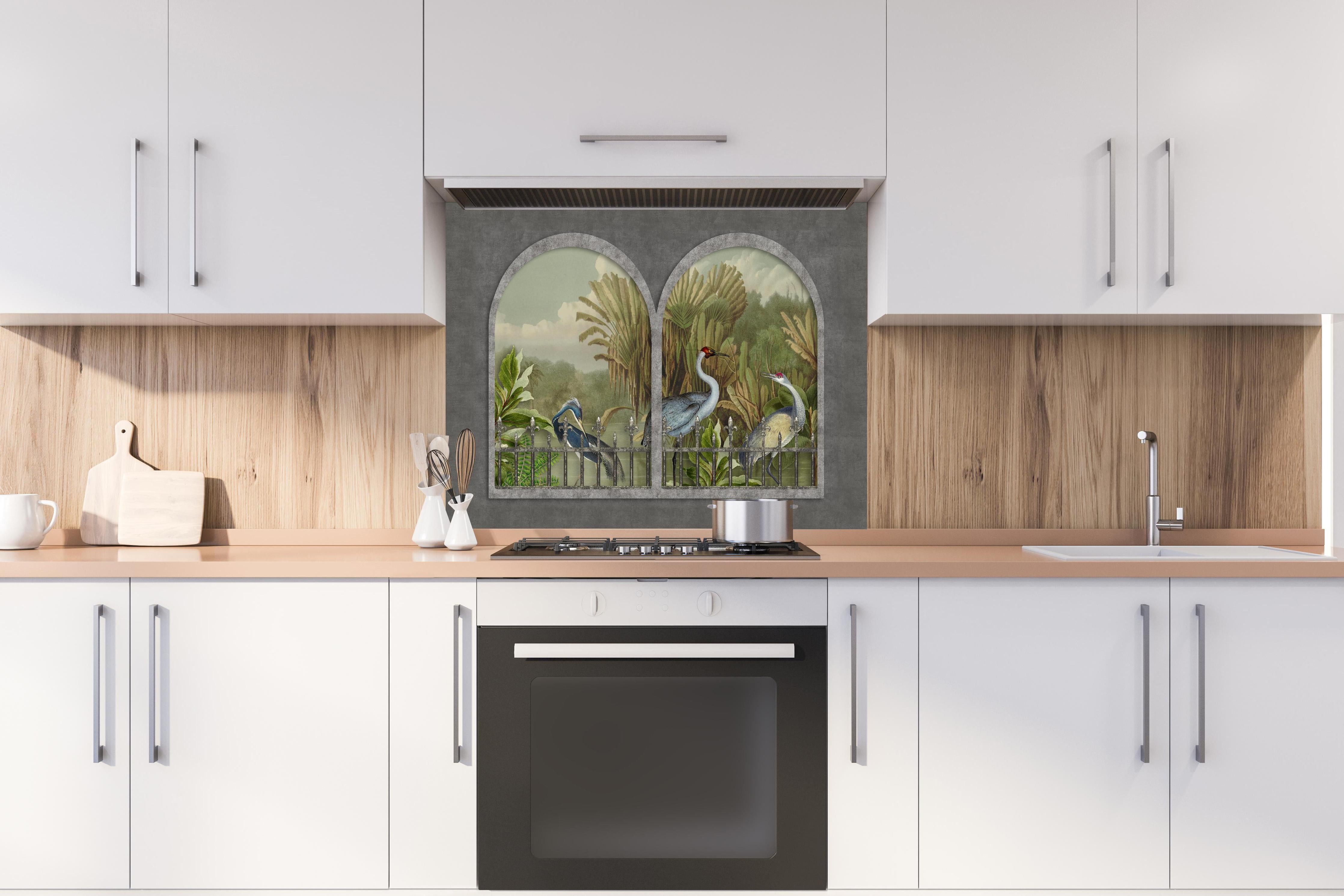 Spritzschutz - Tropischer Dschungel mit Kranichen Motiv hinter einem Cerankochfeld zwischen Holz-Kochutensilien
