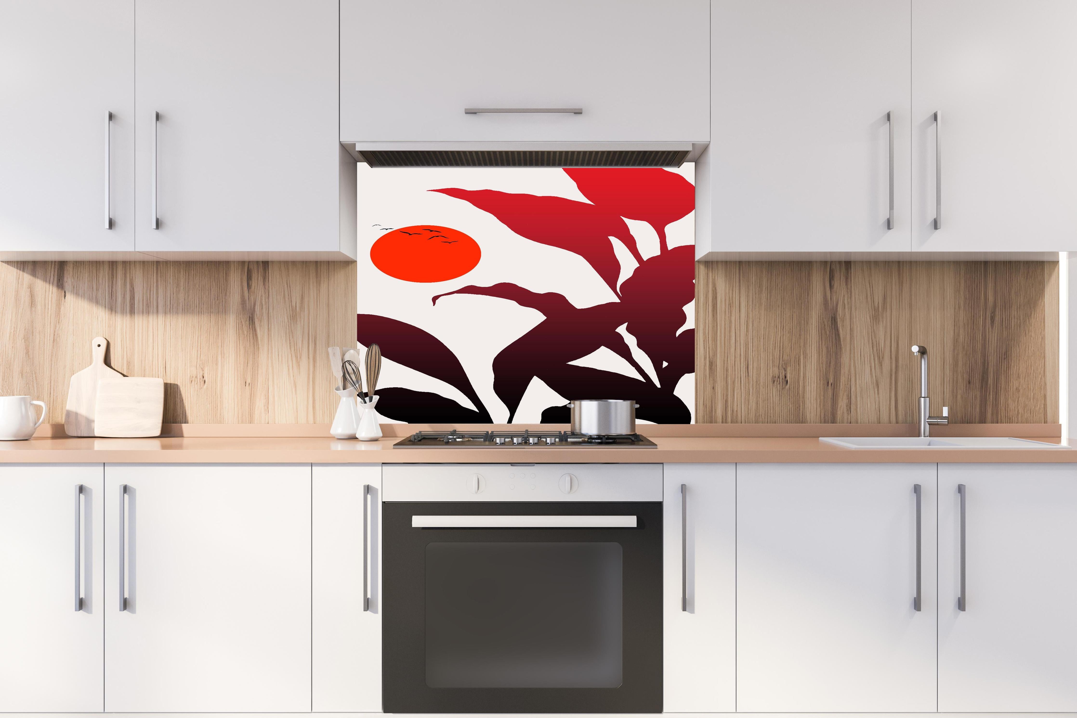 Spritzschutz - Tropischer Sonnenuntergang  hinter einem Cerankochfeld zwischen Holz-Kochutensilien
