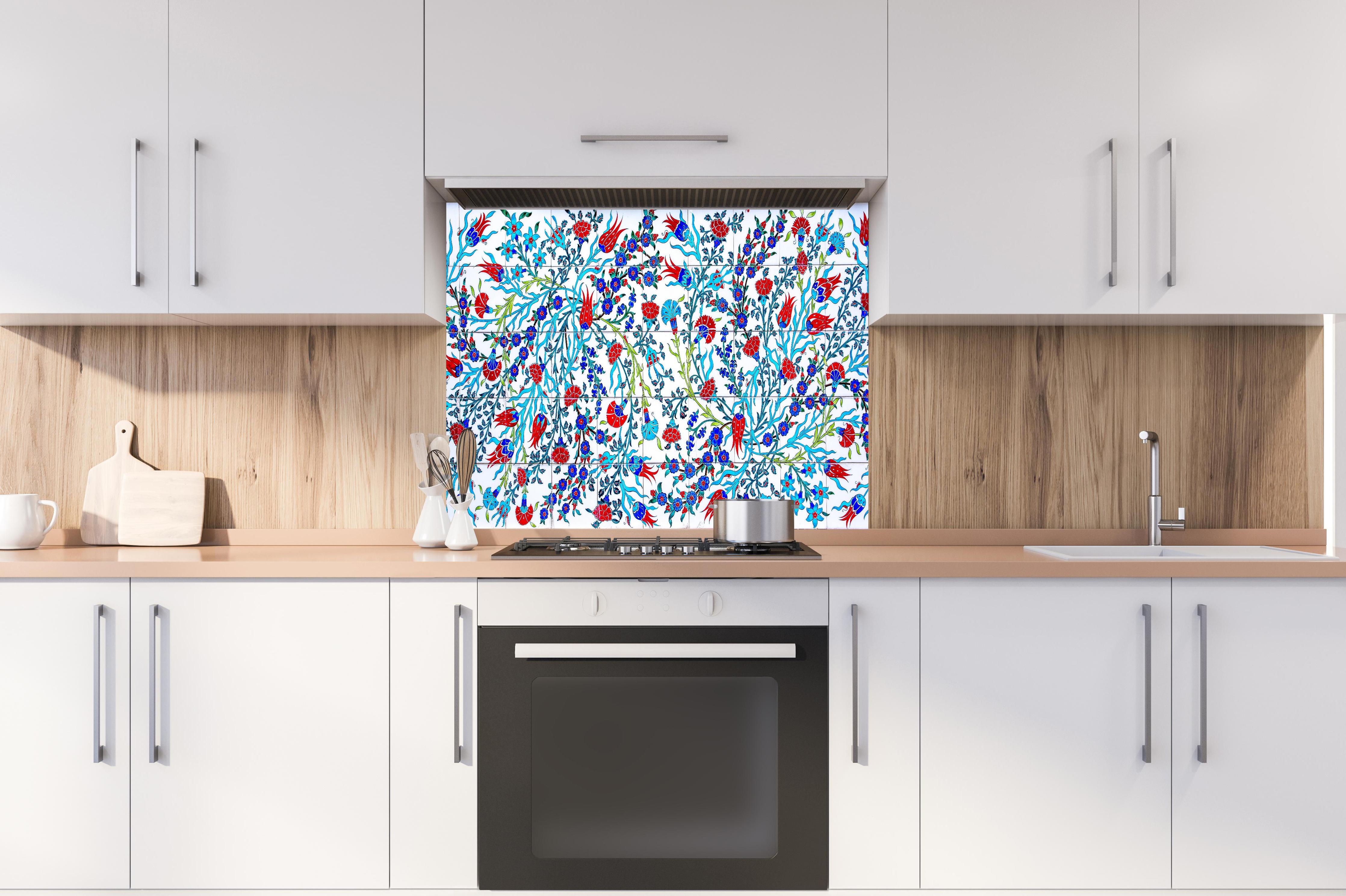 Spritzschutz - Türkische Wandfliese mit floralem Muster hinter einem Cerankochfeld zwischen Holz-Kochutensilien
