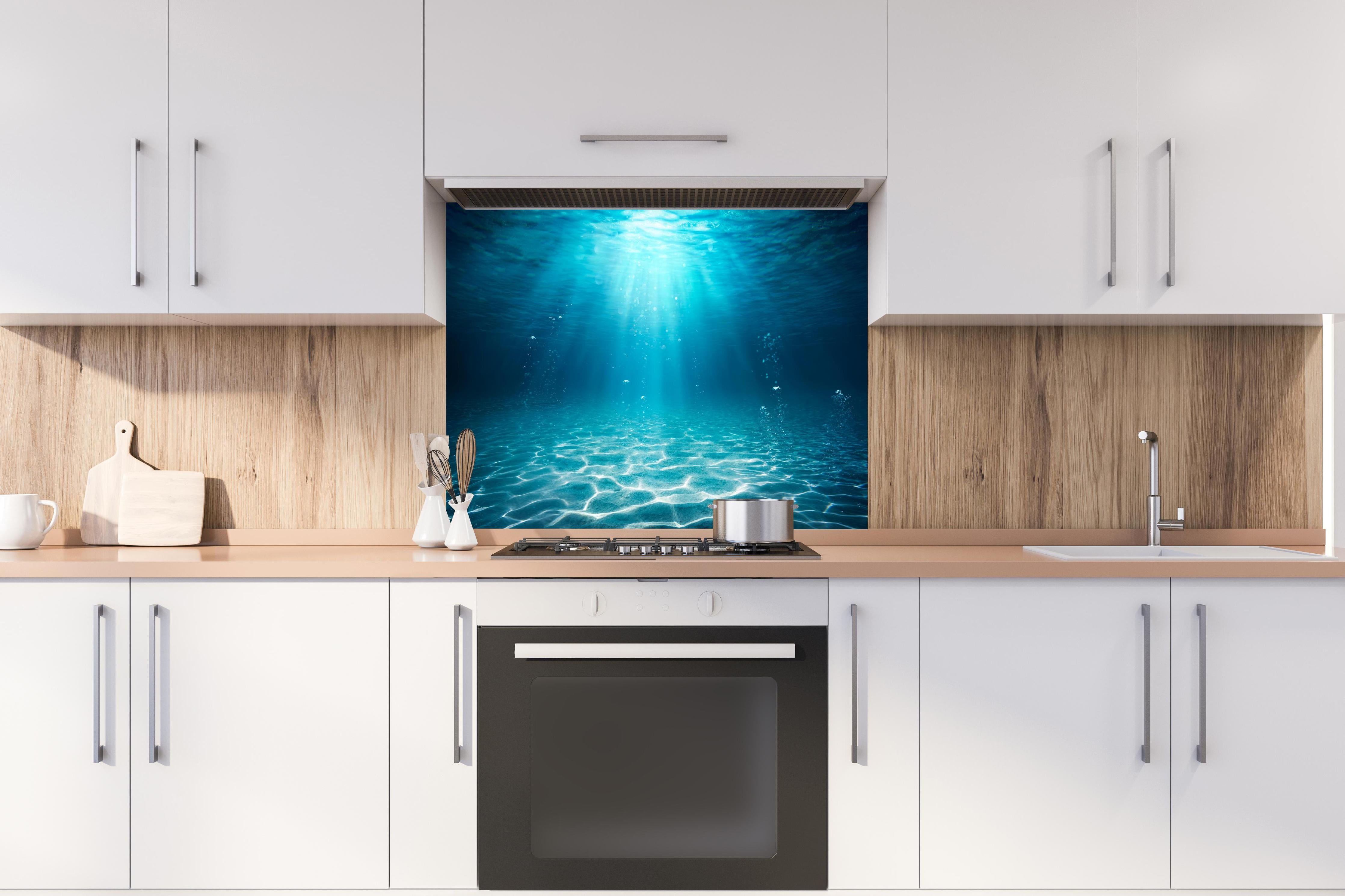 Spritzschutz - Unterwasser Blick - Ozean hinter einem Cerankochfeld zwischen Holz-Kochutensilien
