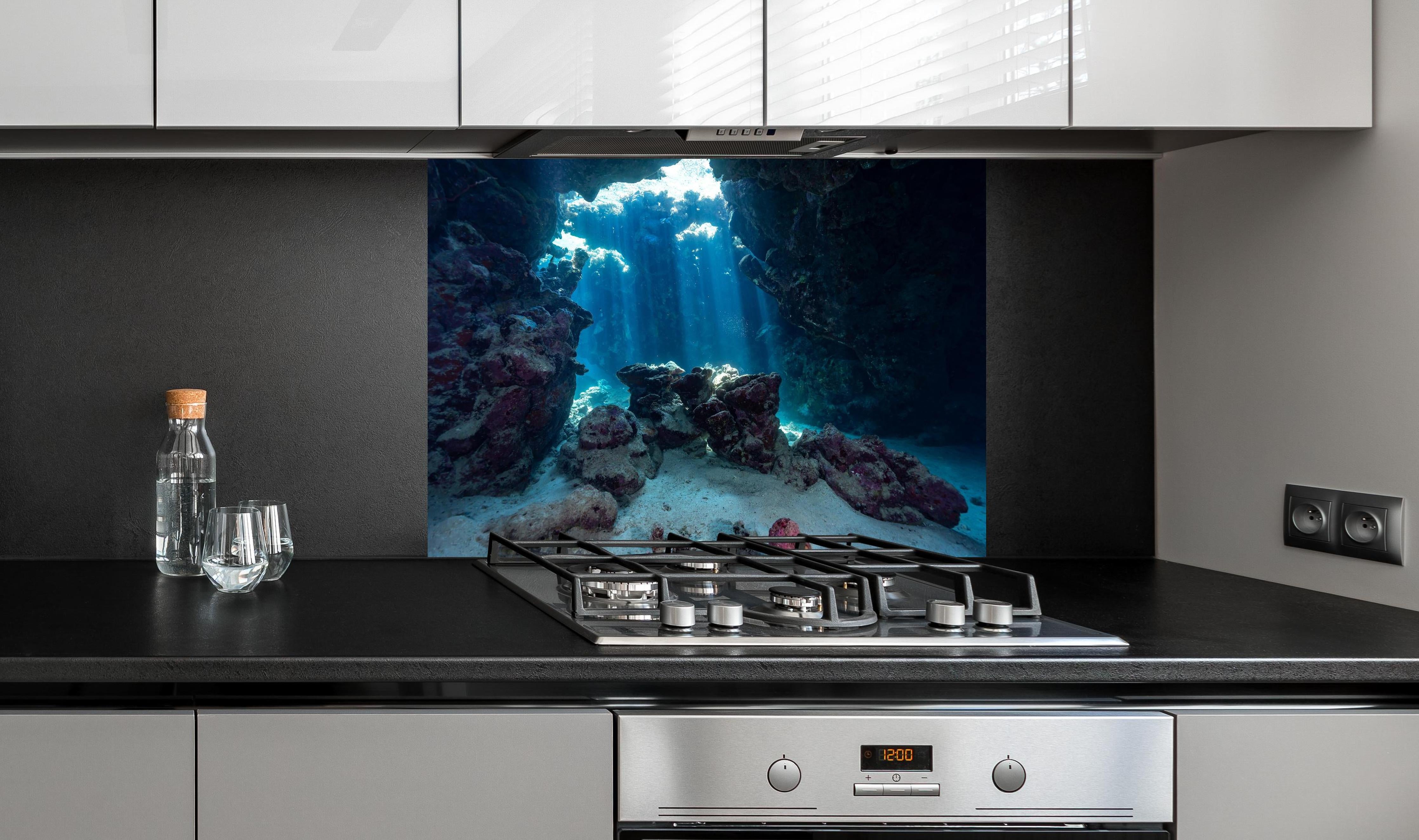 Spritzschutz - Unterwasseransicht eines Riffs hinter einem Cerankochfeld zwischen Holz-Kochutensilien
