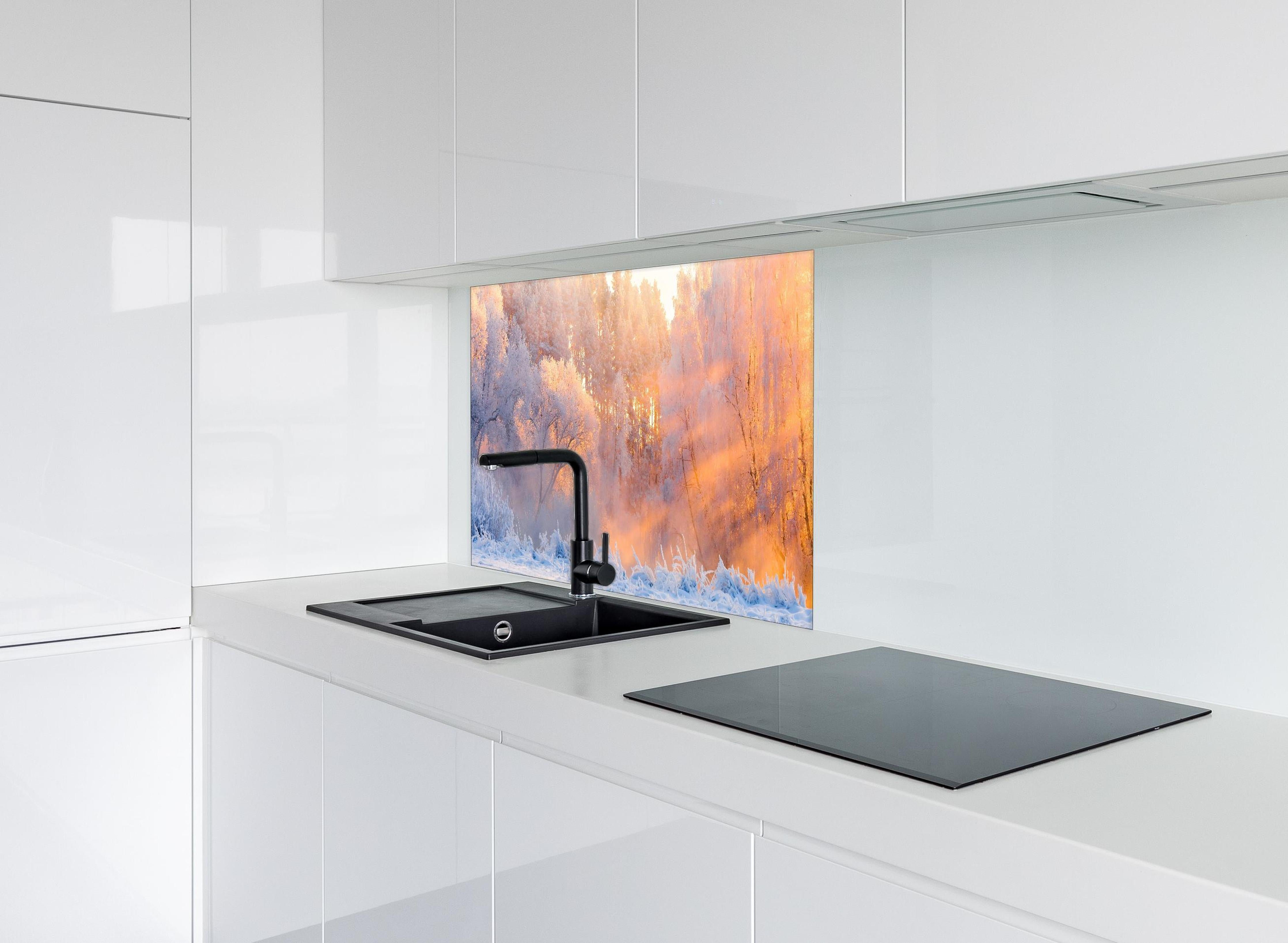 Spritzschutz - Verschneiter Wald im goldenen Morgenlicht hinter einem Cerankochfeld zwischen Holz-Kochutensilien
