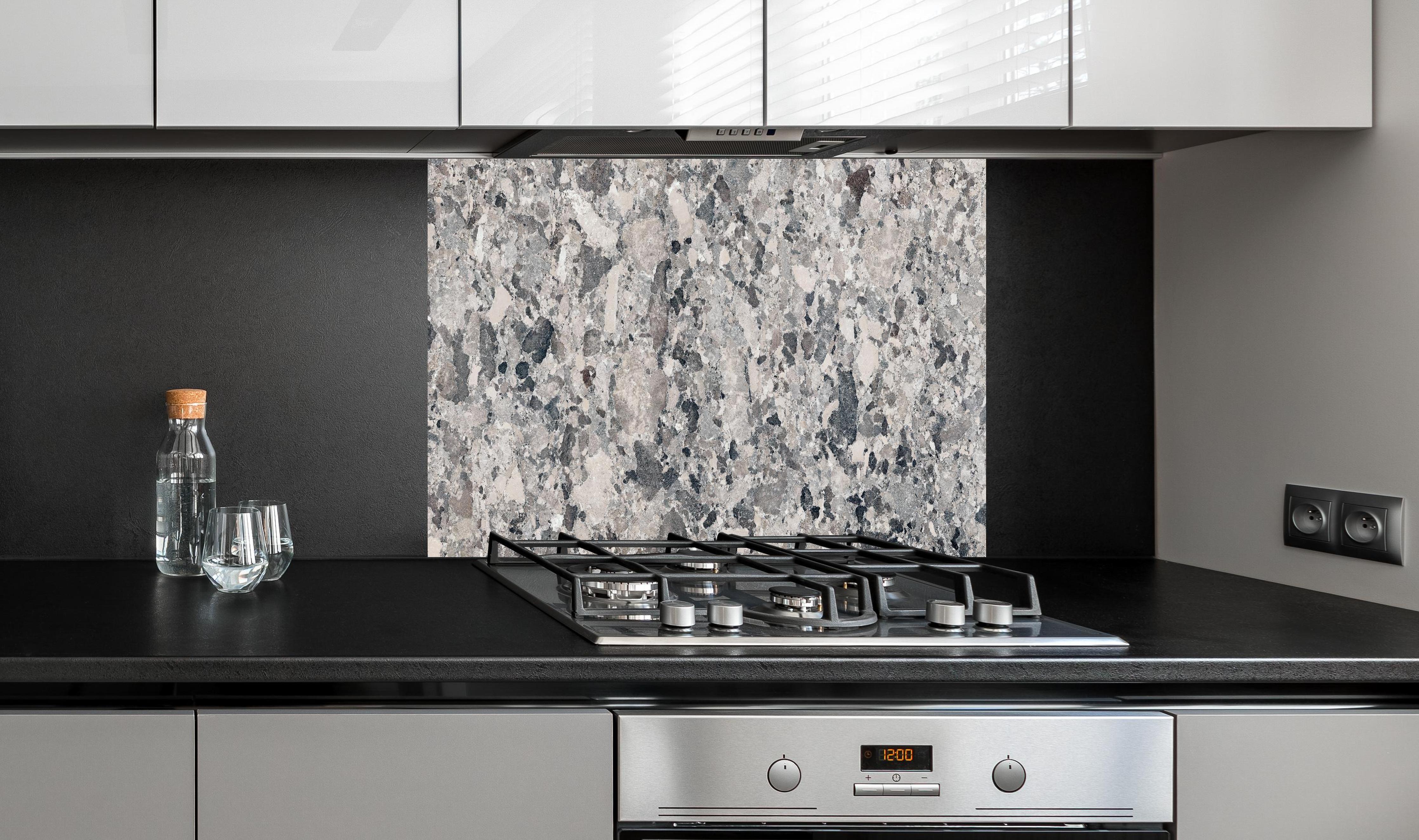 Spritzschutz - Vintage Granit-Textur hinter einem Cerankochfeld zwischen Holz-Kochutensilien
